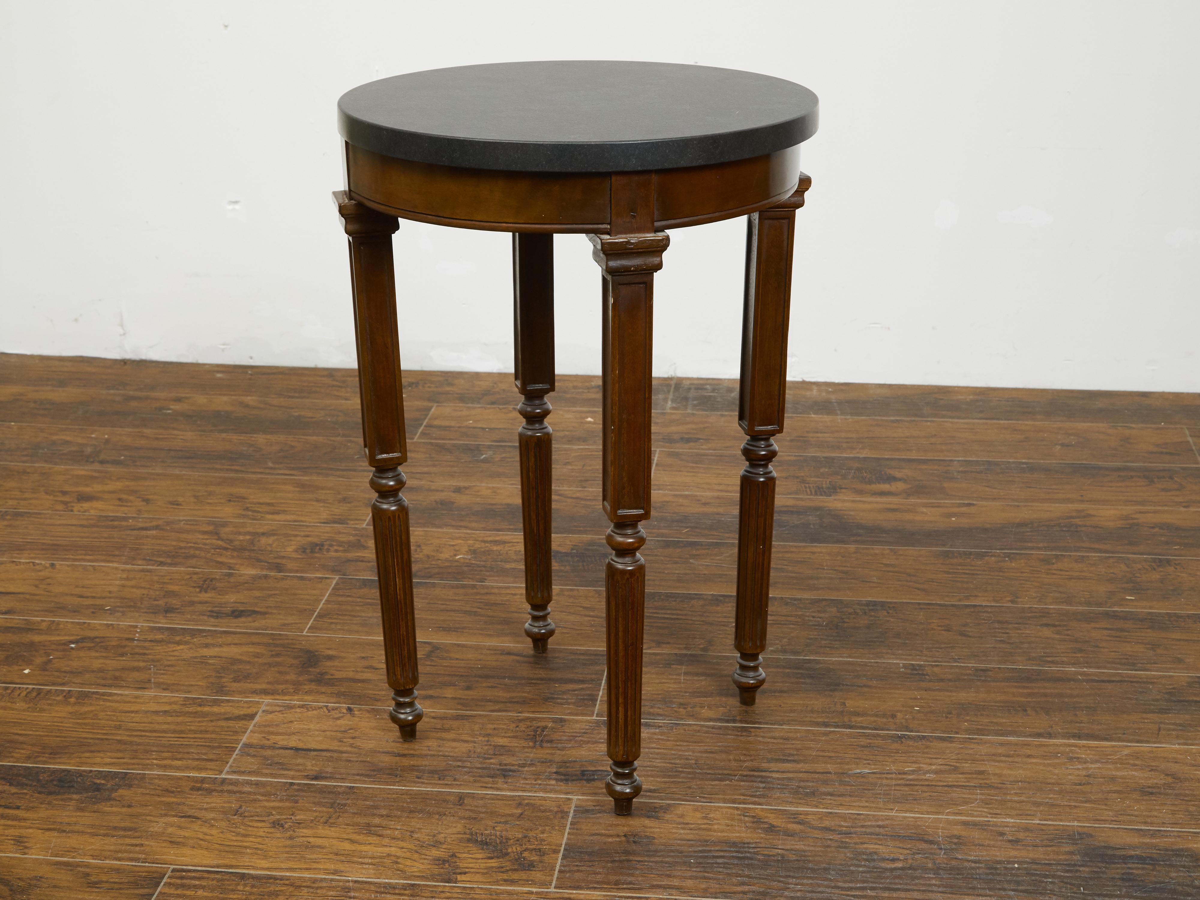 A French wooden guéridon table from the 19th century, with black marble top and unusual legs. Created in France during the 19th century, this guéridon table features a circular black marble top sitting above a simple apron. The table is raised on