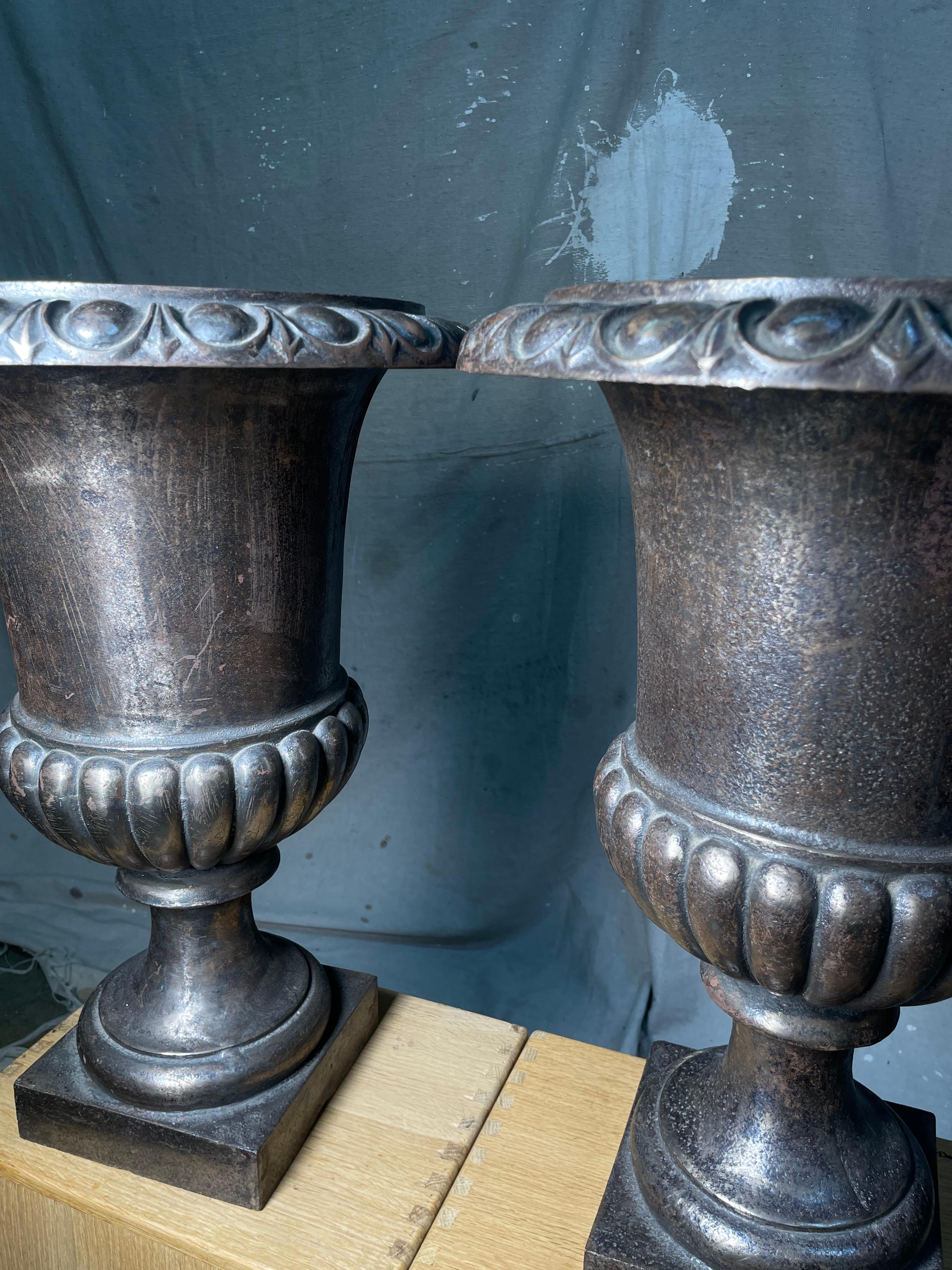 A stunning Neoclassical Wrought Iron Jardiniere or Urn with a pedestal base; their sturdy construction gives them substantial weight so you can count on them to stand strong. An egg and dart design covers the top rim of this sturdy urn, with 2