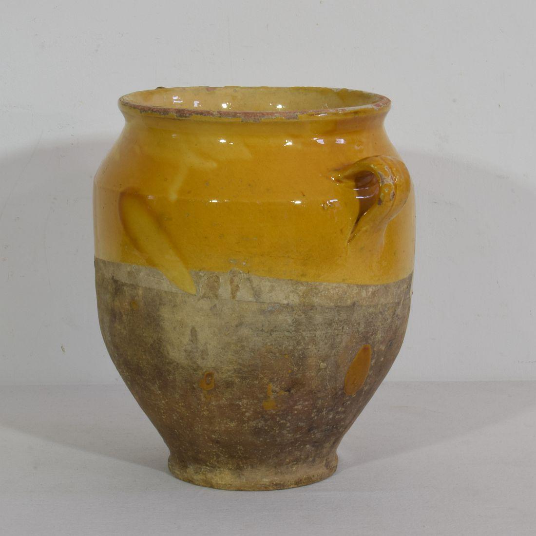 Beautiful confit jar with its characteristic yellow glaze. 
Confit jars were used primarily in the South of France for the preservation of meats such as duck or goose for dishes such as cassoulet or foie gras. The bottom halves were left unglazed,