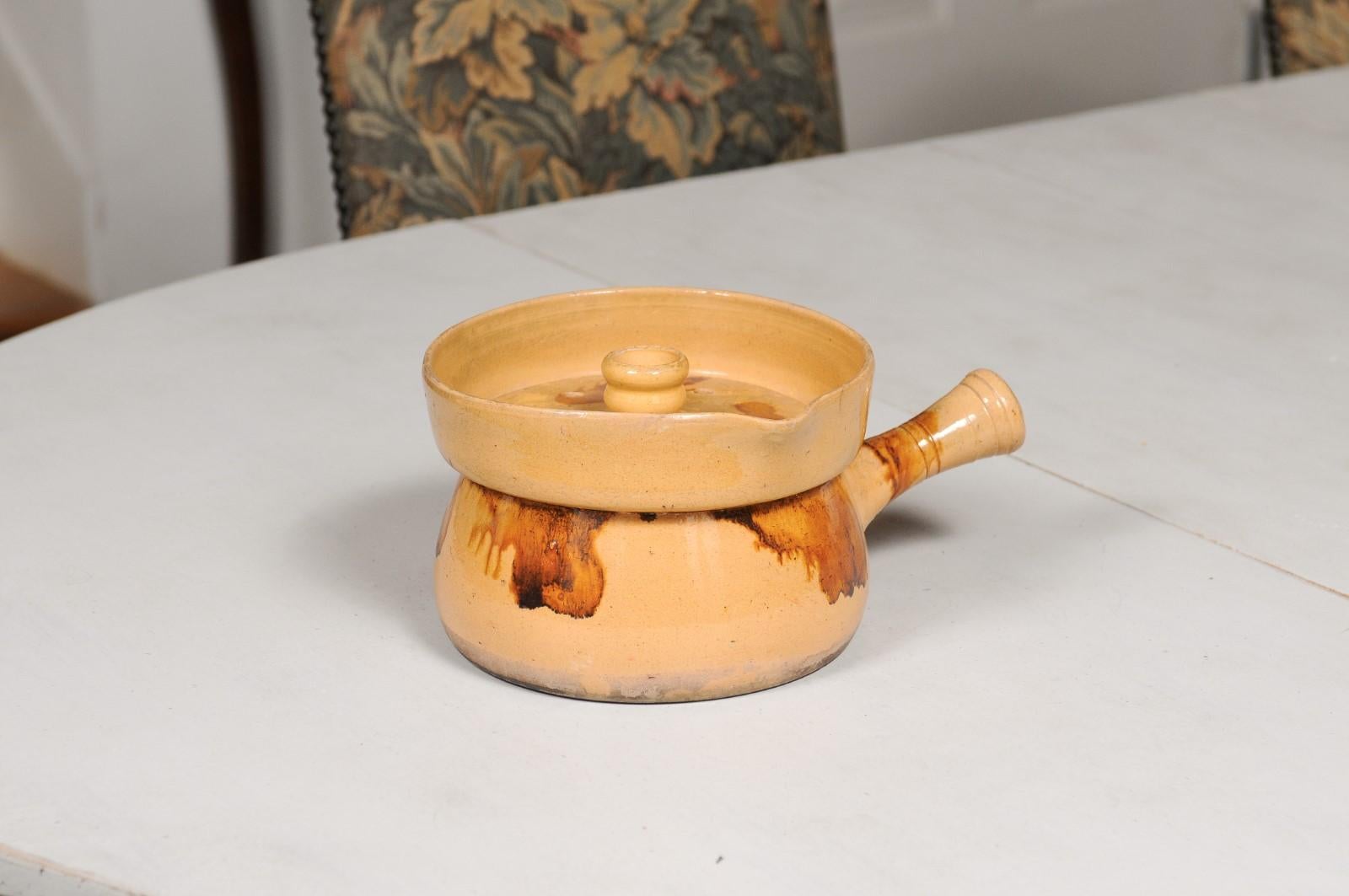 A French pottery steamer from the 19th century, with lid and rust accents. Created in France during the 19th century, this pottery steamer features a circular yellow glazed body adorned with rust toned accents. Topped with a lid and showcasing a