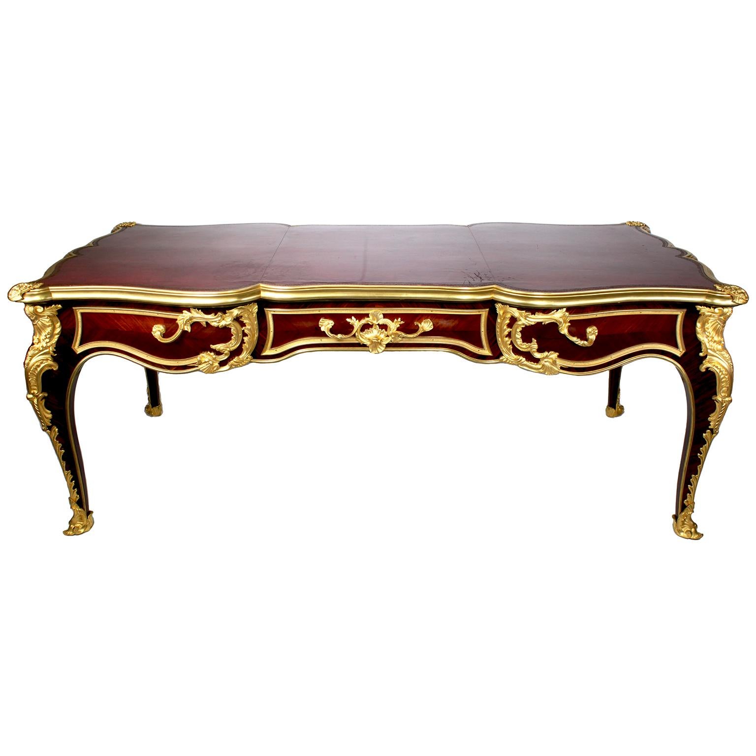 A Very Fine and Large French 19th Century Louis XV Style Ormolu Mounted Tulipwood Three-Drawer Bureau Plat - After a model by Joseph Baumhauer (died 1772) - Attributed to Paul Sormani (French-Italian 1817-1877). The serpentine shaped rectangular top