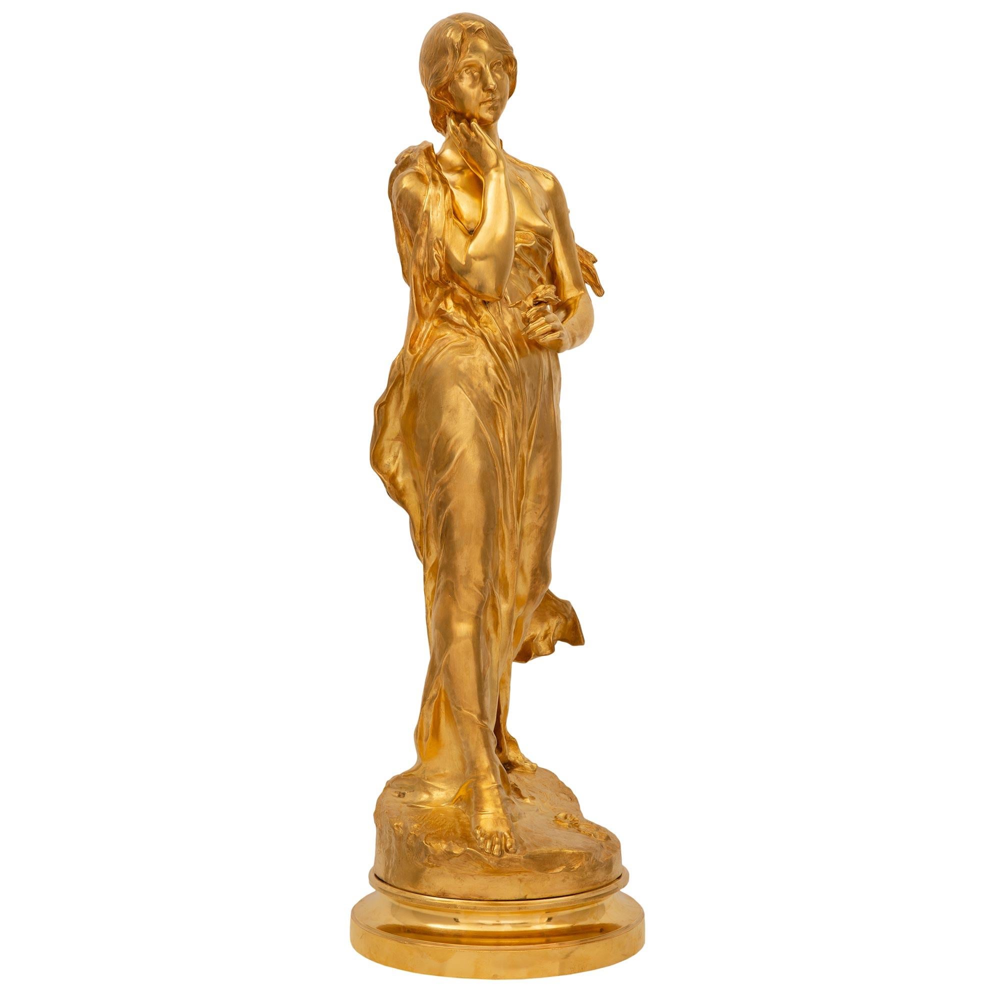 A stunning and large scale French 19th Louis XVI st. Belle Époque period signed ormolu statue of a beautiful maiden. The statue is raised by an elegant circular mottled base with a wonderfully executed ground like design. The beautiful maiden above