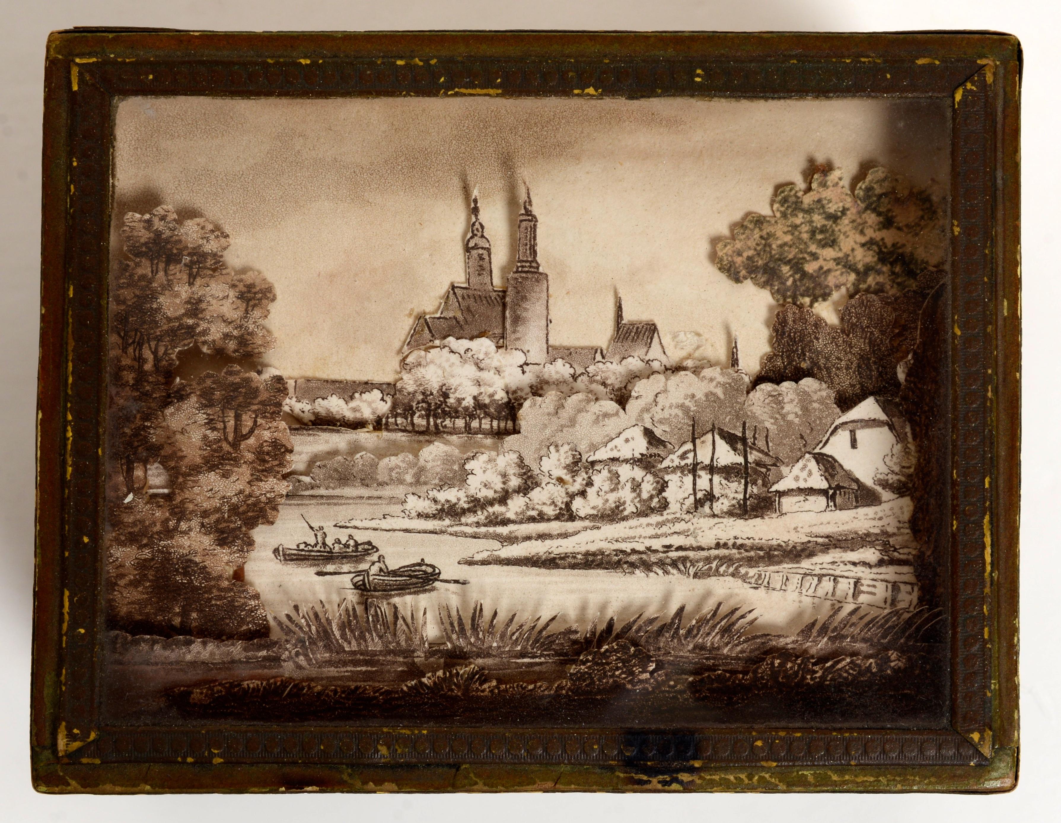 French 19th c paper covered box with what appears to be a 3D diorama of the Strasbourg cathedral under a glass covered top. These paper boxes were designed to be sold as souvenirs and because of the fragility of the paper construction not many have