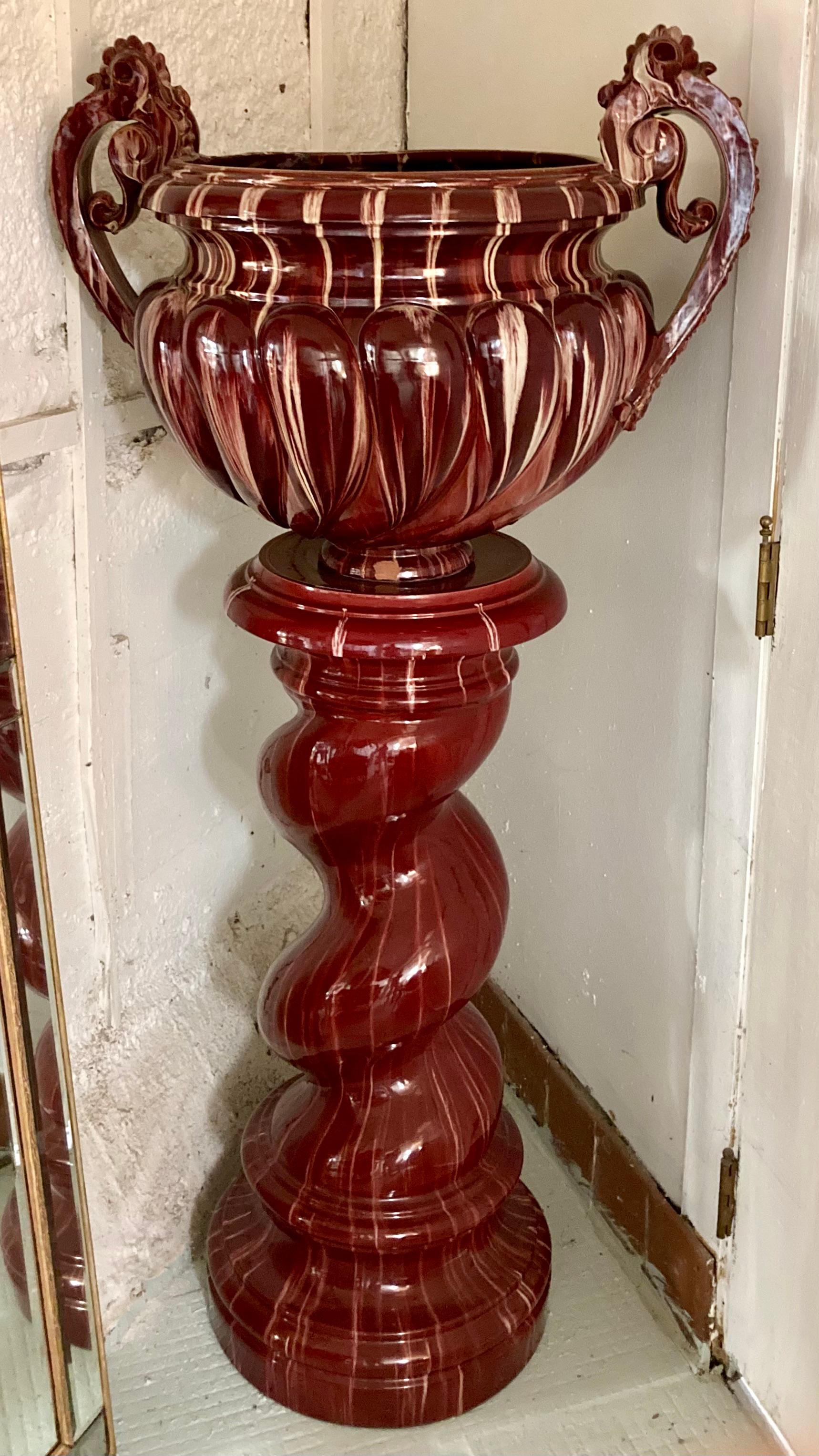 Beautiful glazed burgundy terra cotta urn on a pedestal by French artist Jerome Massier. Great addition to your classic French inspired interiors. Some wear and chips but adds to the character.