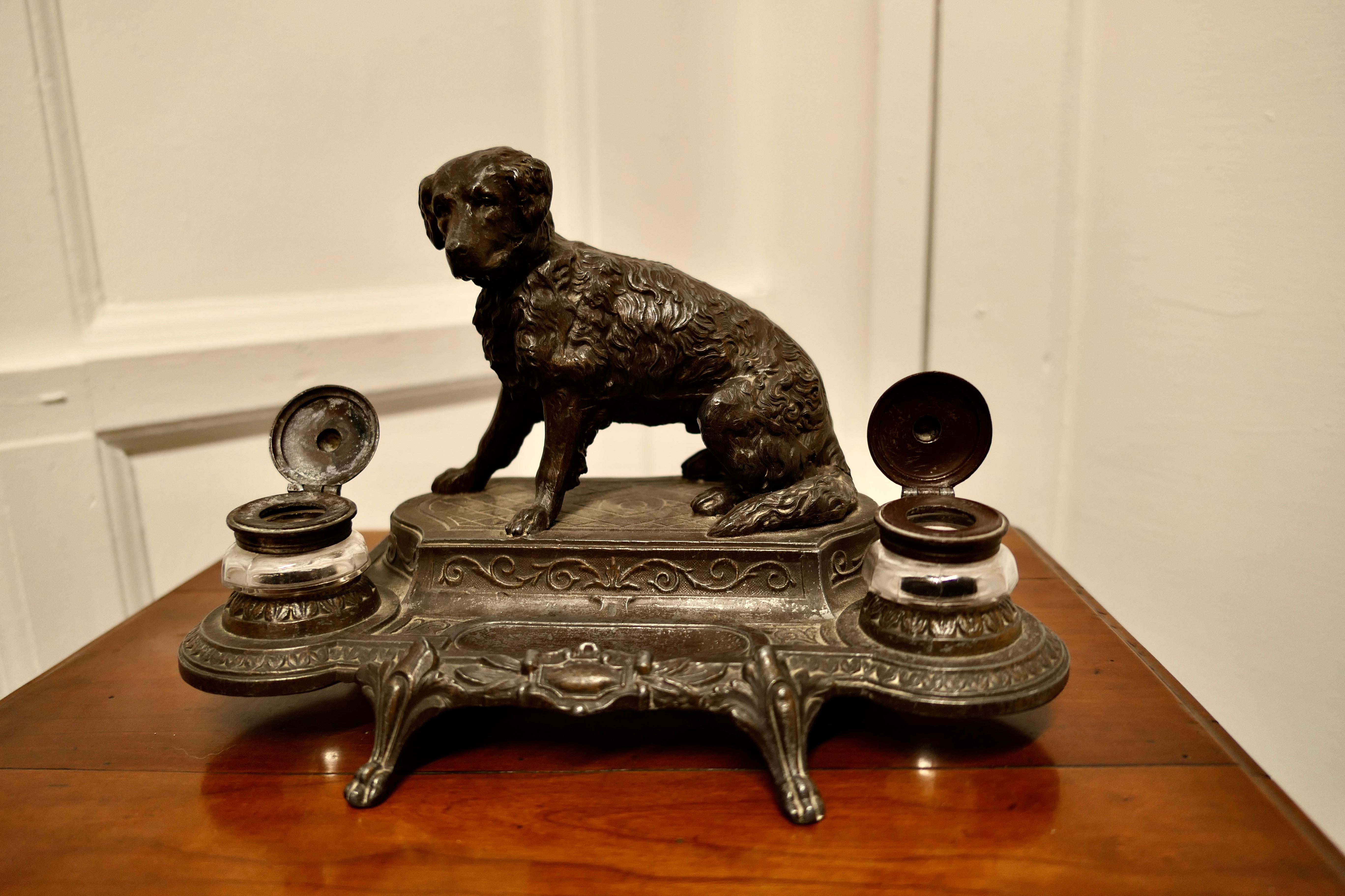 French 2 pot inkwell stand with a Hunting Retriever Dog

This is a very attractive desk top inkwell, the centre of the stand is set with a curly coated retriever in front of him there is a pen rest and on each side a glass ink pot, all of the