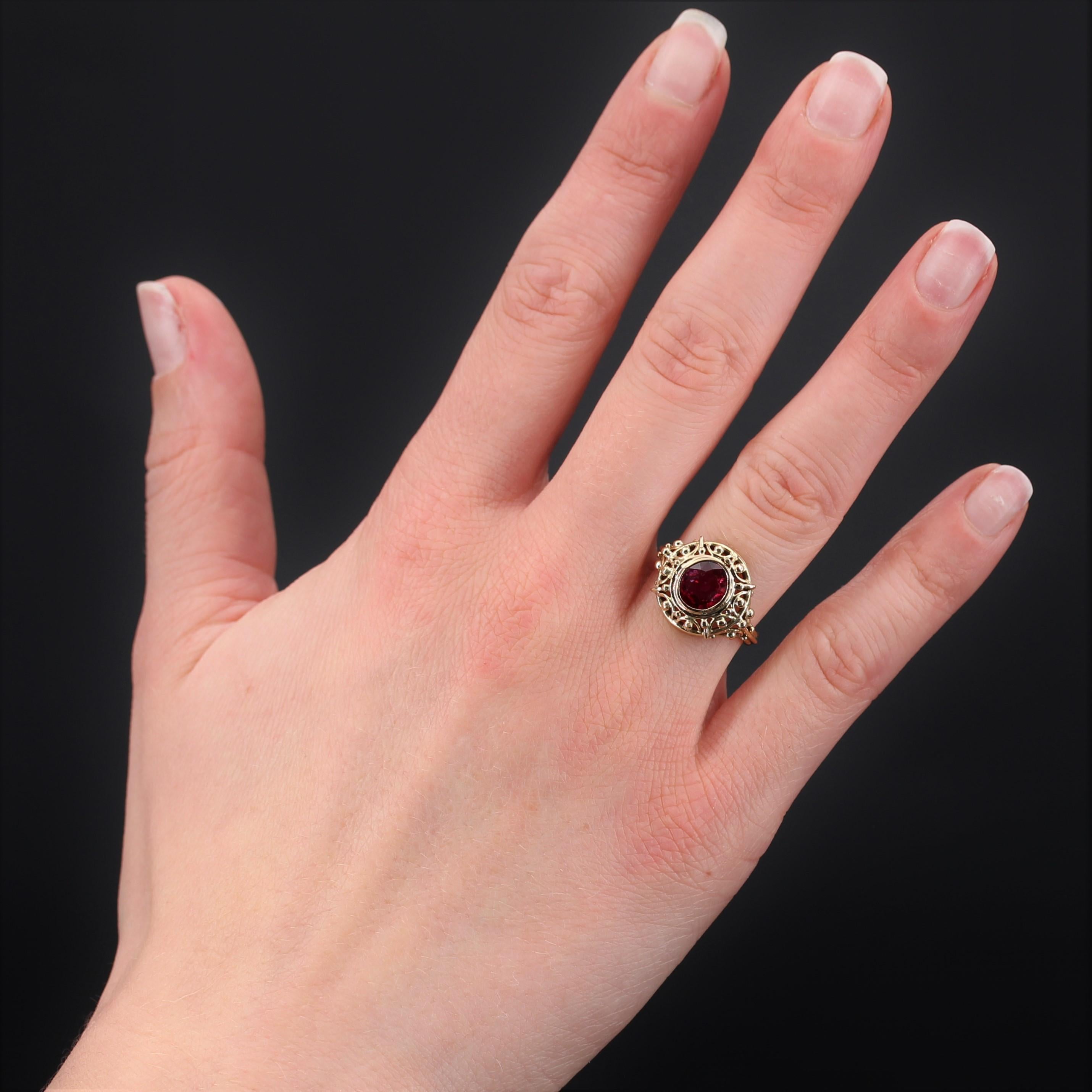 Ring in 18 karat yellow gold, eagle head hallmark.
Splendid yellow gold setting, it is openworked of gold arabesques, strewn with small gold pearls and decorated in its center in closed setting of a cushion- cut ruby of the most beautiful