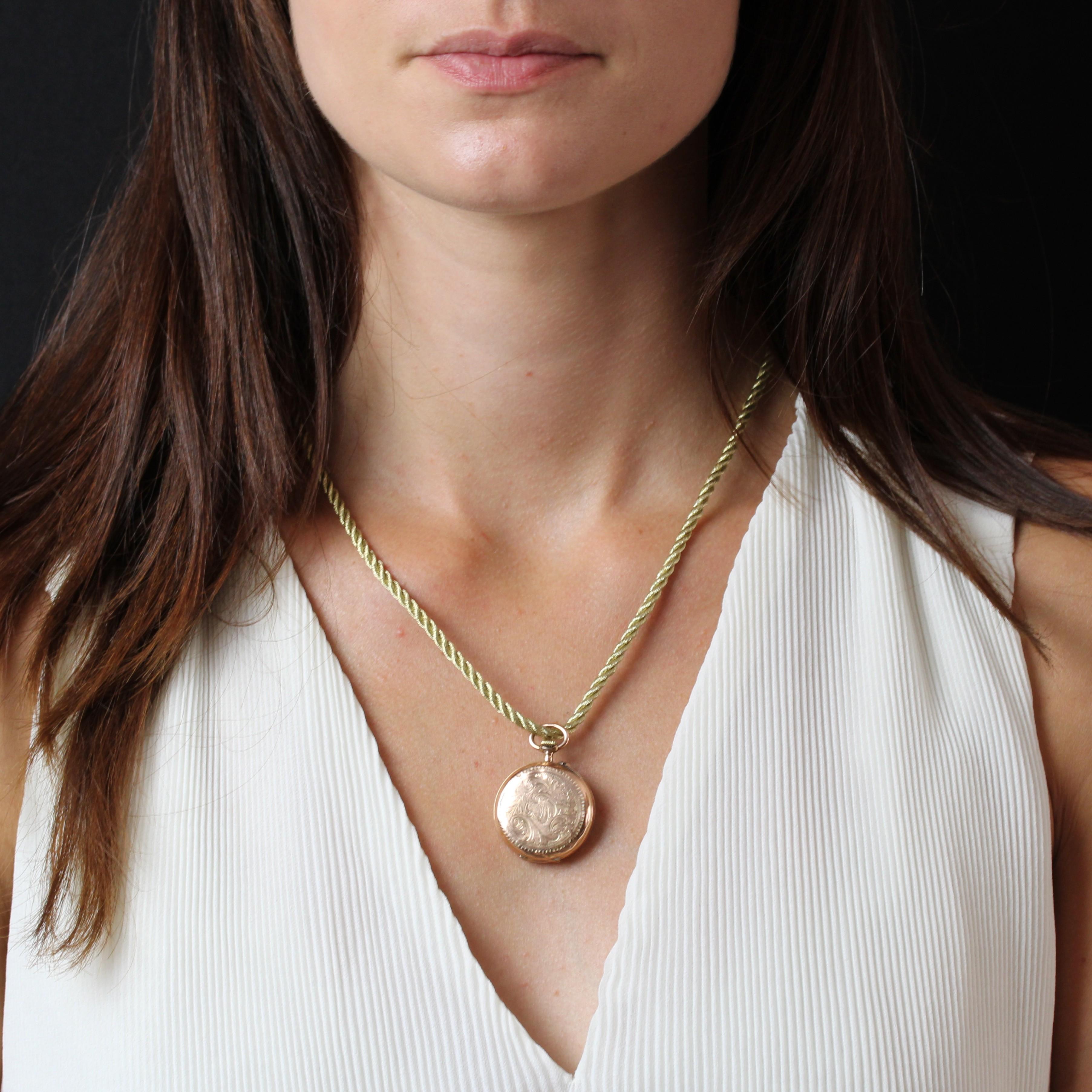 Montre-pendentif en or rose 18 carats, poinçon tête de cheval.
Montre ancienne de collier pour femme avec un boîtier rond. Le fond est en émail blanc crème et or, avec des aiguilles en or et des chiffres romains en émail noir. Le dos est gravé de