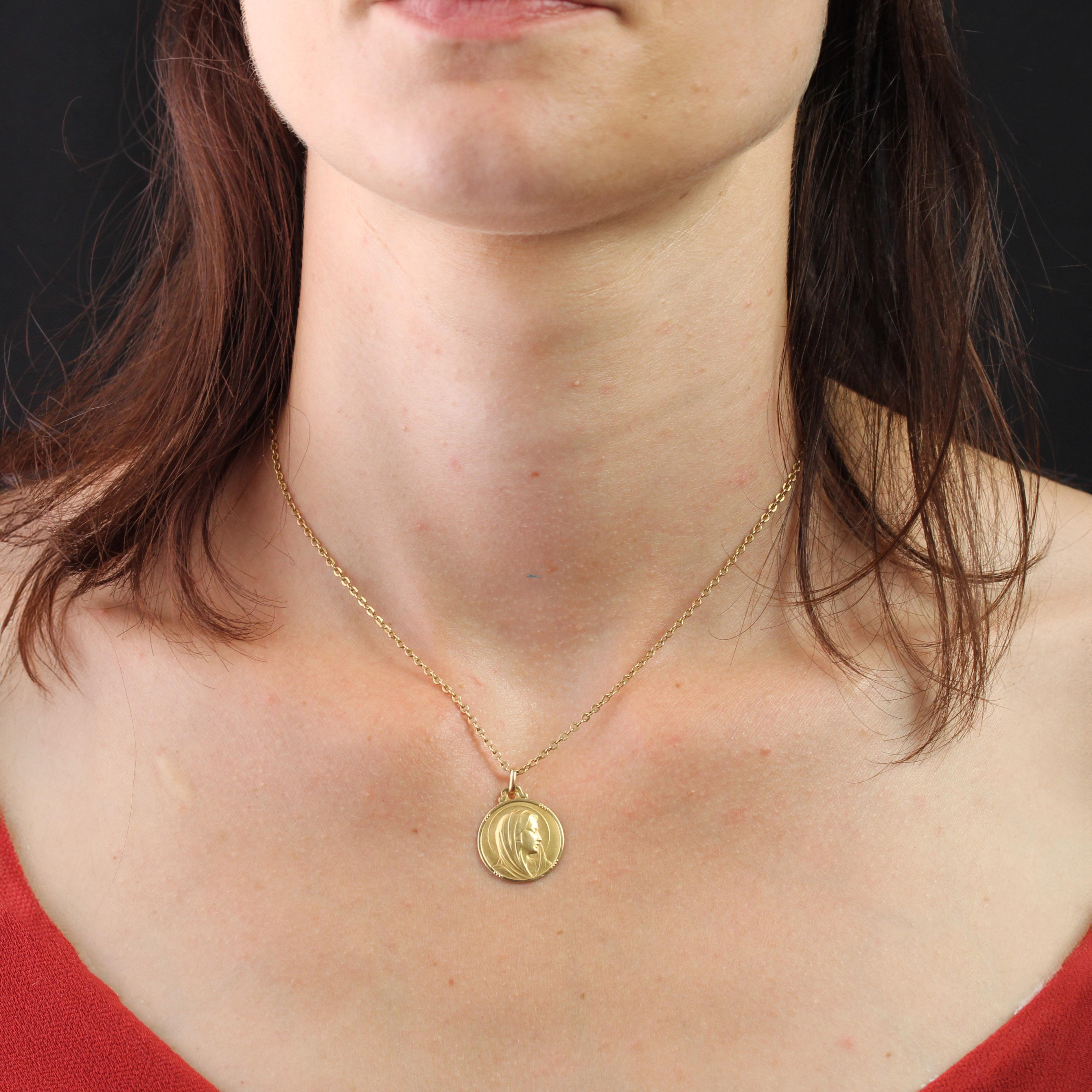 Medal in 18 karat yellow gold, eagle head hallmark.
This religious pendant features the profile of the Virgin Mary in matte yellow gold, bordered on both sides by 4 pearl motifs.
The back is engraved with the initials “AMD” and the date