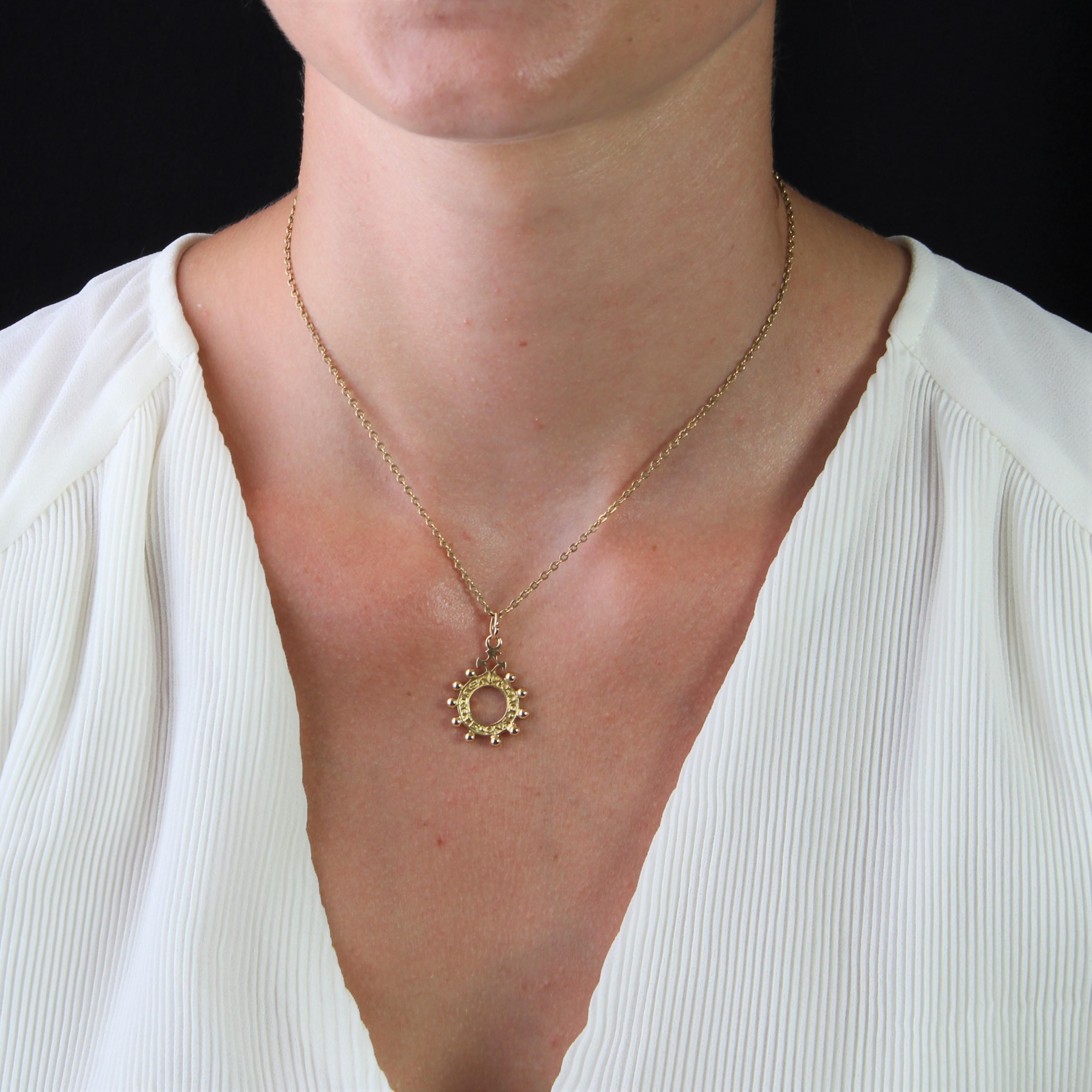 Pendant in 18 karat rose gold.
A Basque dizainier pendant, it forms an openwork circle adorned with 10 gold beads and the words 