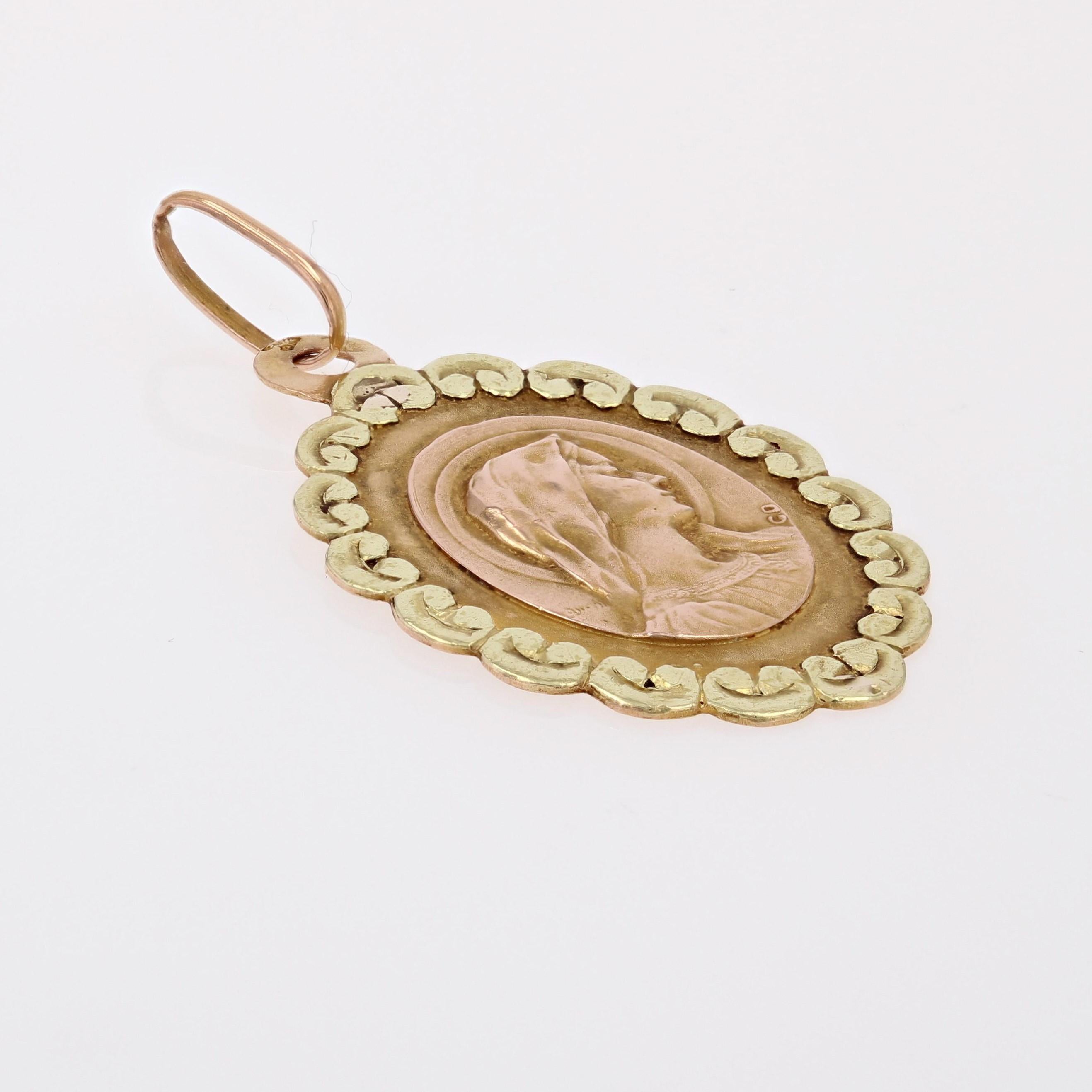 Médaille en or rose et jaune 18 carats, poinçon tête d'aigle.
Charmante médaille ovale en or rose, elle présente en son centre le profil de la Vierge Marie auréolé et bordé de motifs polylobés en or jaune.
Le dos de ce pendentif antique est gravé du