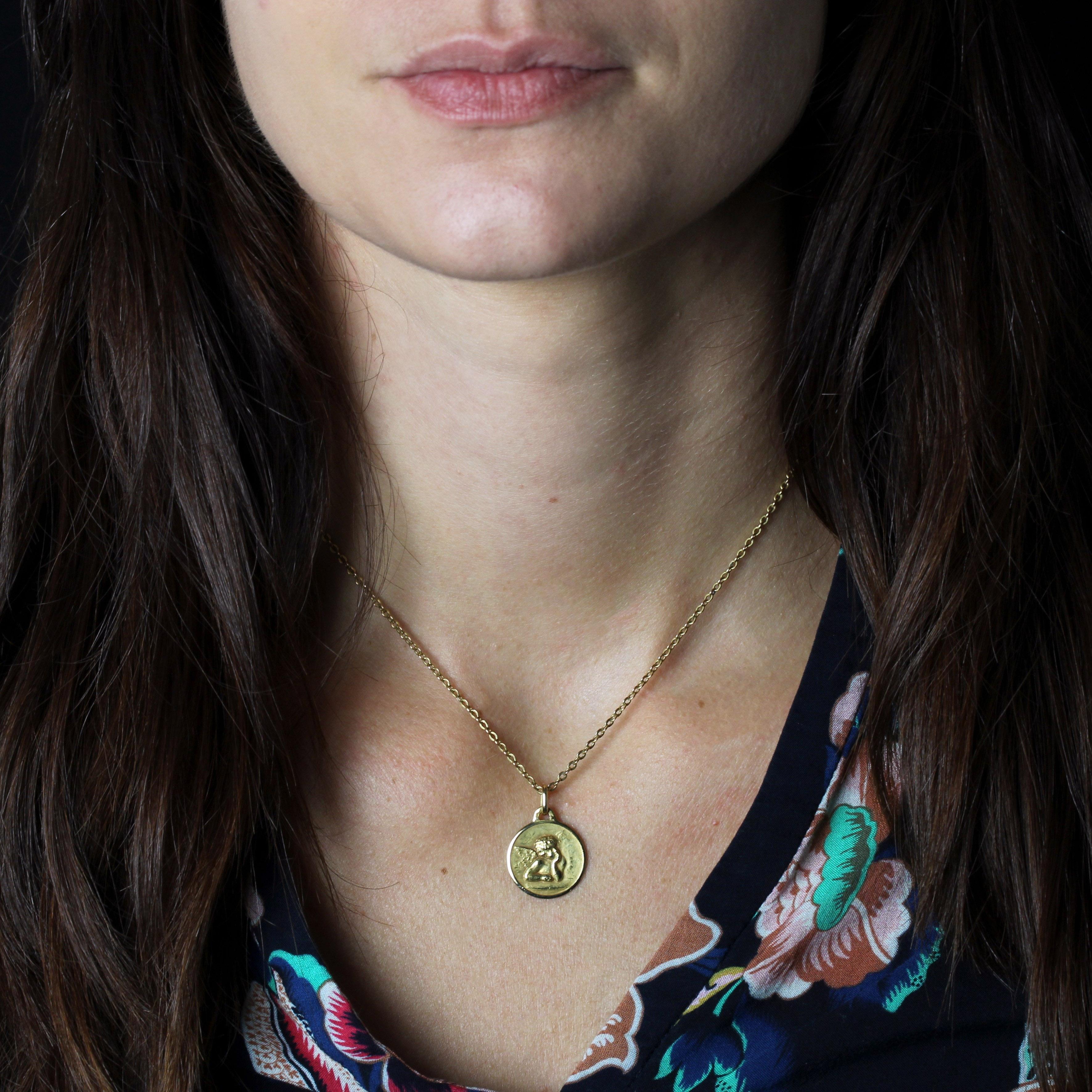 Médaille en or jaune 18 carats, poinçon tête d'aigle.
Cette médaille ronde représente un chérubin. Le dos est gravé du nom de Catherine et de la date du 