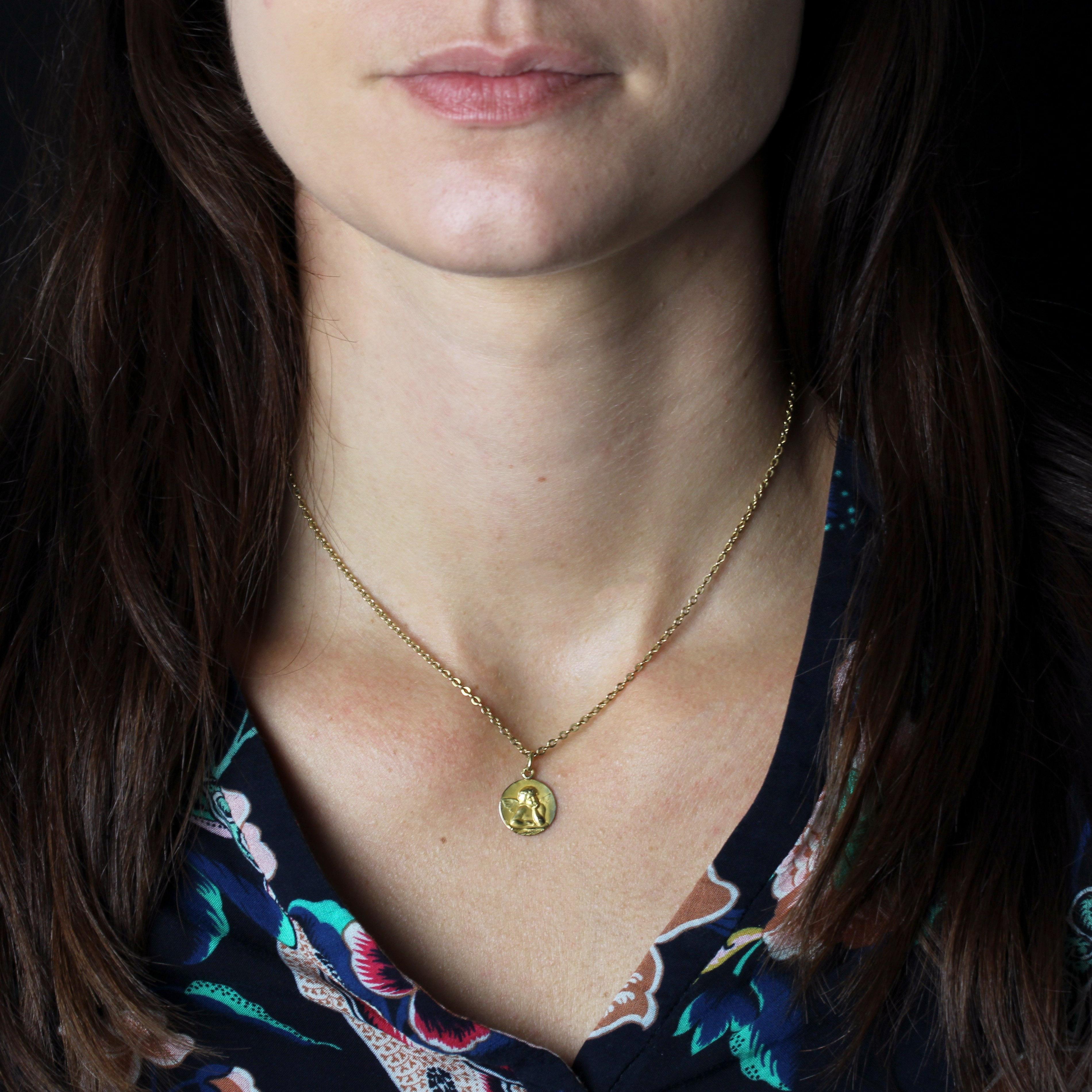 Médaille en or jaune 18 carats, poinçon tête d'aigle.
Une petite médaille ronde représentant un chérubin.
Médaille signée des initiales LB.
Pendentif vendu seul sans sa chaîne de présentation.
Hauteur : 2,2 cm environ, largeur : 12,5 mm environ,