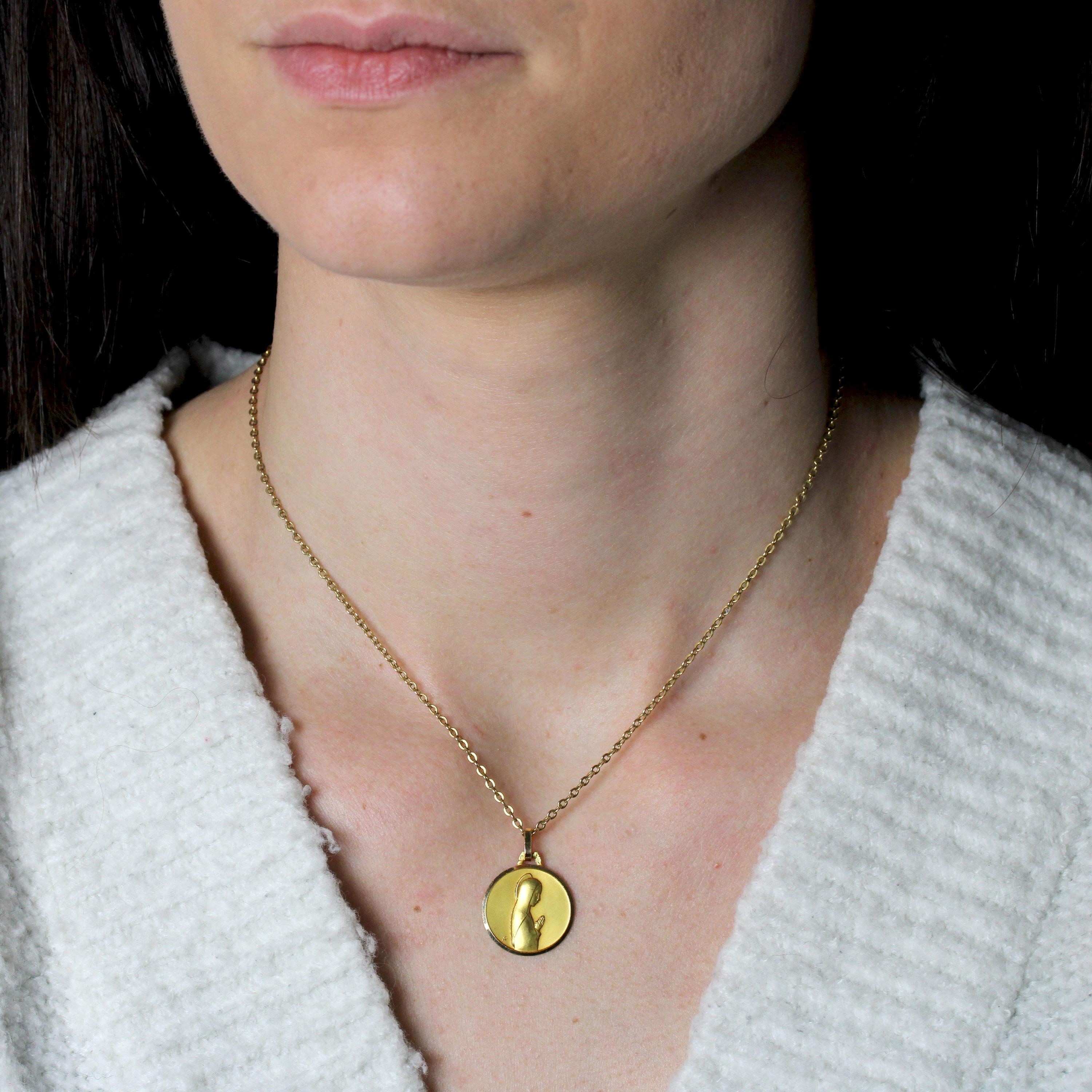 Medal in 18 karat yellow gold, eagle head hallmark.
Round in shape, this yellow gold christening medal depicts the Virgin Mary at prayer.
Medal signed AP.
Pendant sold alone without its chain of presentation.
Height : 2,5 cm approximately, width at