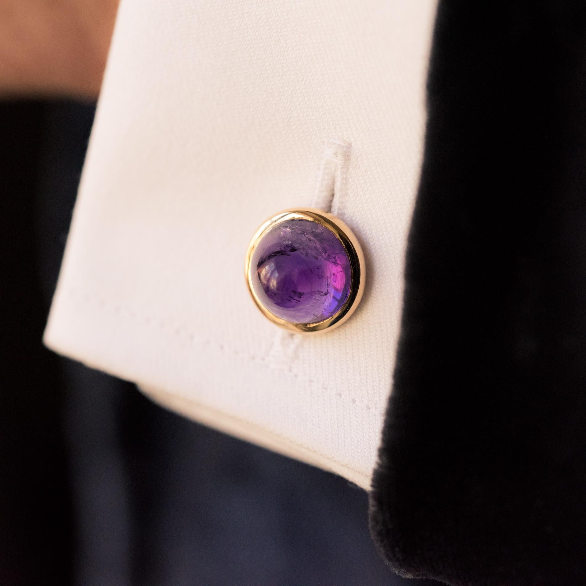 Pair of cufflinks in 18 karat yellow gold, eagle's head hallmark.
Each antique, round cufflink is adorned with a sugar loaf amethyst in a closed setting and retained with a gold wheat grain, by three small links.
Diameter: 12.5mm, thickness: about