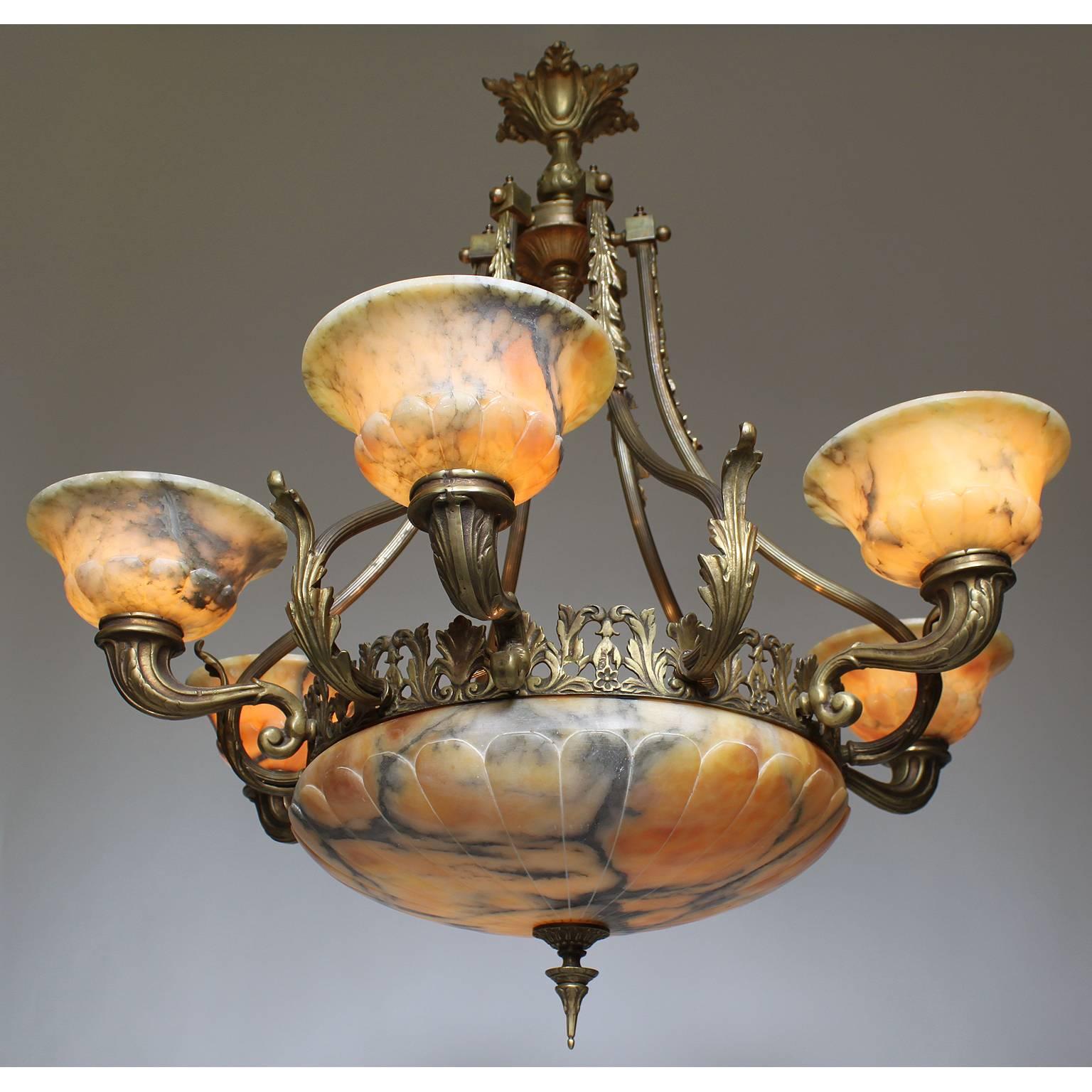 A French 20th century Art Deco bronze and veined caramel- colored alabaster six-light chandelier. The carved circular alabaster plafonnier with a floral apron and banded frame with six alabaster lights supported by cornucopia shaped bronze cups and
