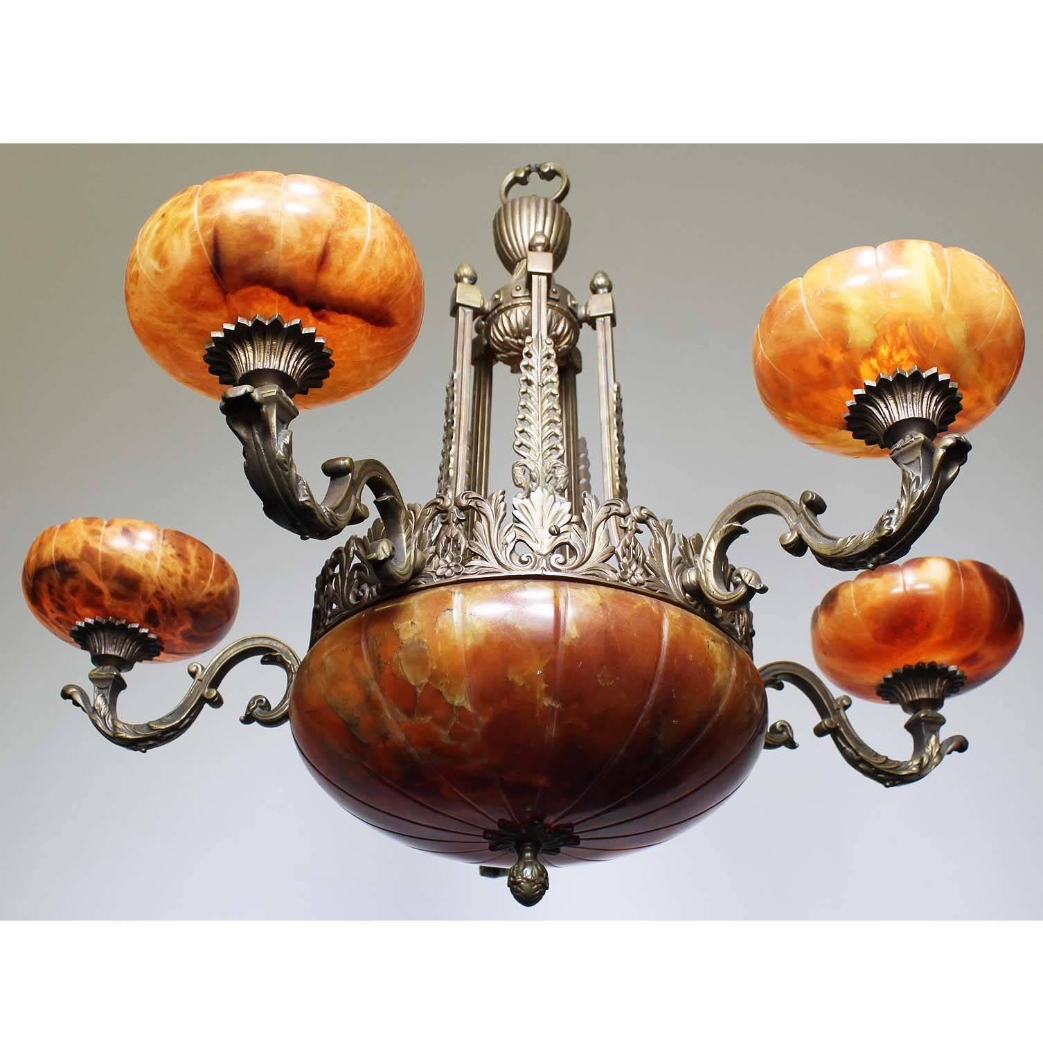 A French 20th century Art Deco bronze and carved veined caramel-colored alabaster five-light chandelier. The carved circular alabaster plafonnier, with two interior lights, on a floral apron and banded bronze frame surmounted with five 