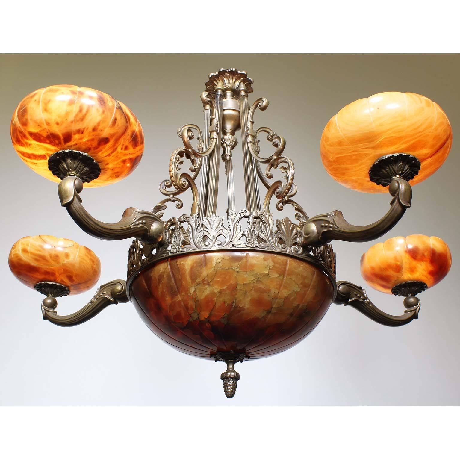 A French 20th century Art Deco bronze and carved veined caramel-colored alabaster five-light chandelier. The carved circular alabaster plafonnier, with two interior lights, on a floral apron and banded bronze frame surmounted with five 