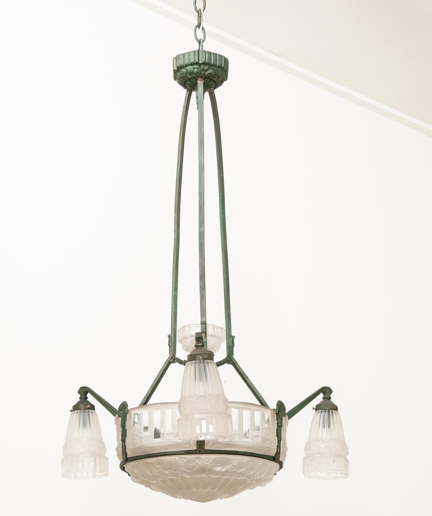 This exquisite Art Deco chandelier was hand-crafted in France during that artful period between 1925 and the end of the 1930s. Made of clear frosted molded glass and adorned with curvilinear and geometric skyscraper detailing and intricate molded