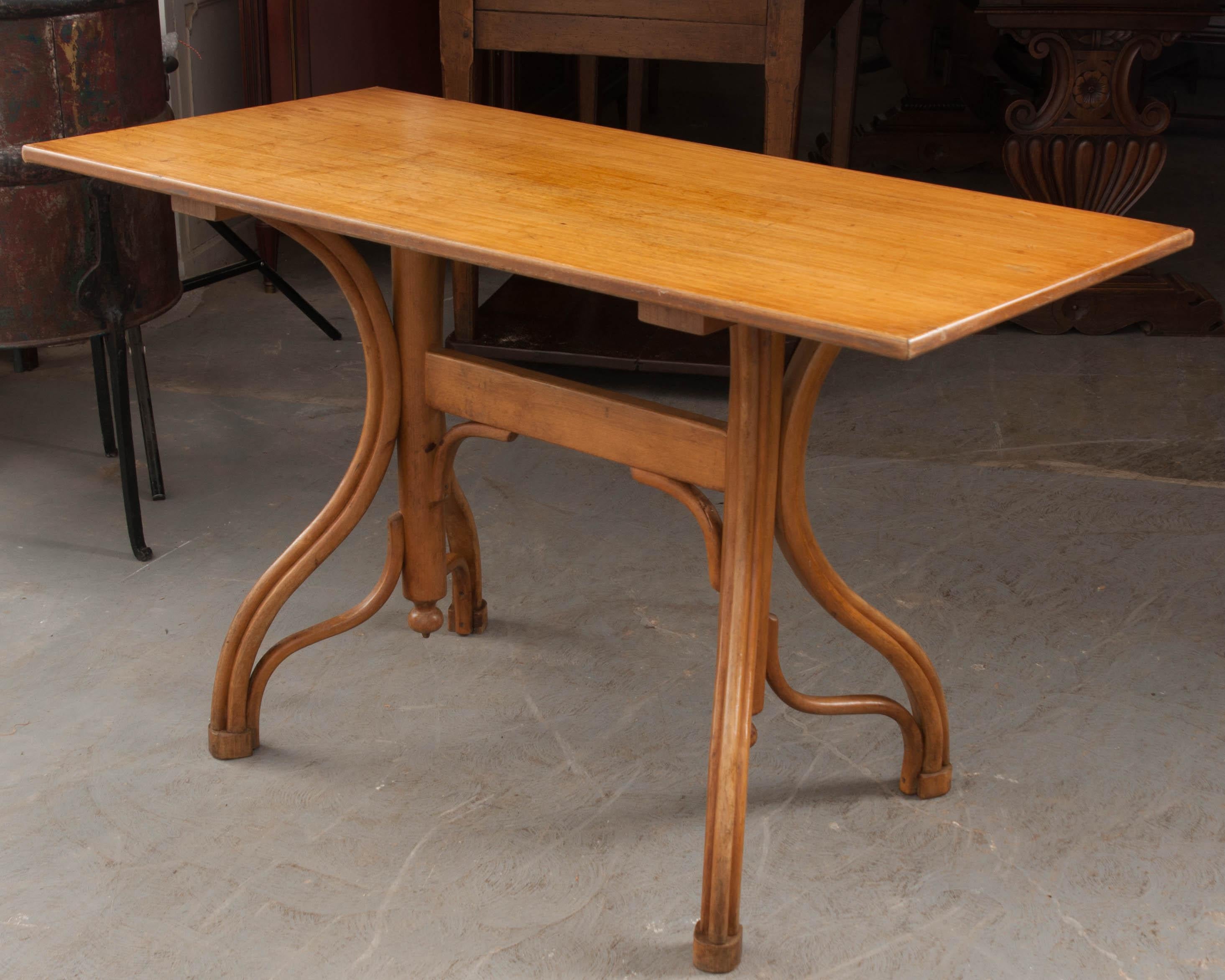 This excellent example of a French Art Nouveau pine bistro table, circa 1900, is of rectangular section and features elegant bentwood legs so quintessential to the period. In addition to working well as a small dining table, it would be a fantastic