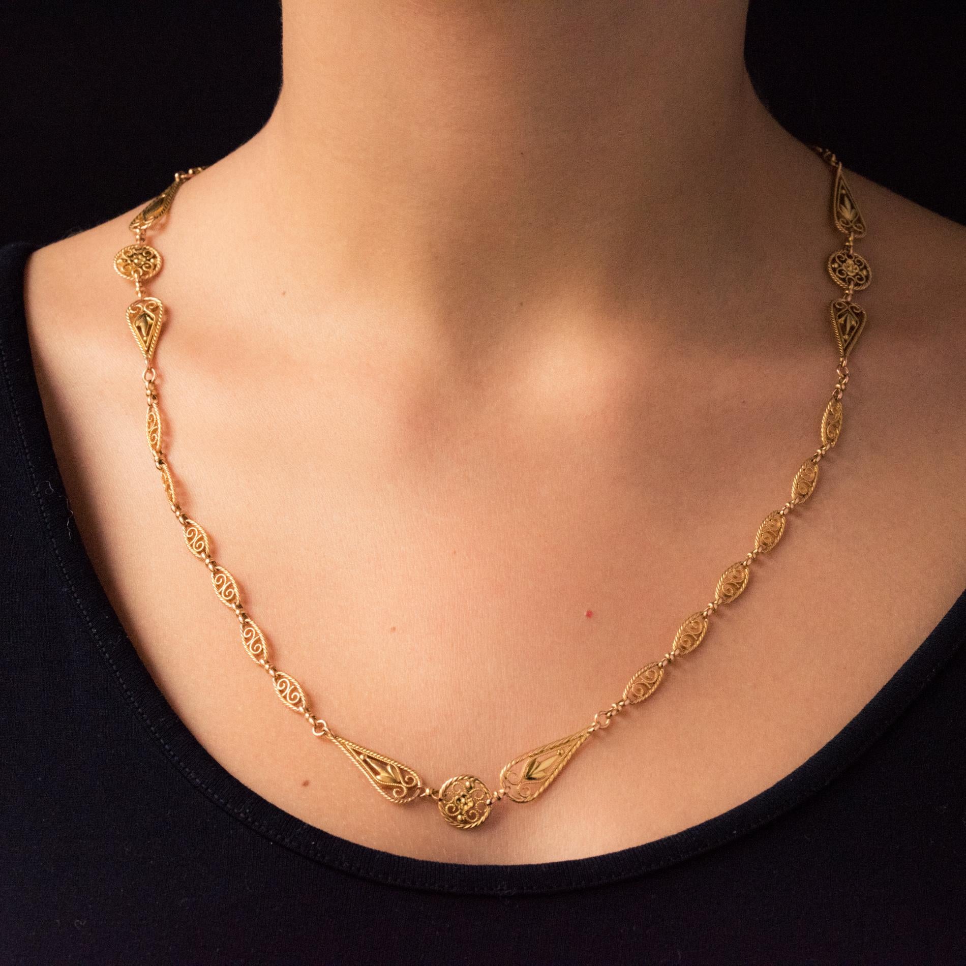 Chain in 18 karat yellow gold, horse's head hallmark.
Elegant antique necklace, it consists of filigree openwork shuttle links, separated by disks of the same pattern and each supported by 2 openwork pear links. The clip is a spring ring.
Length: 59