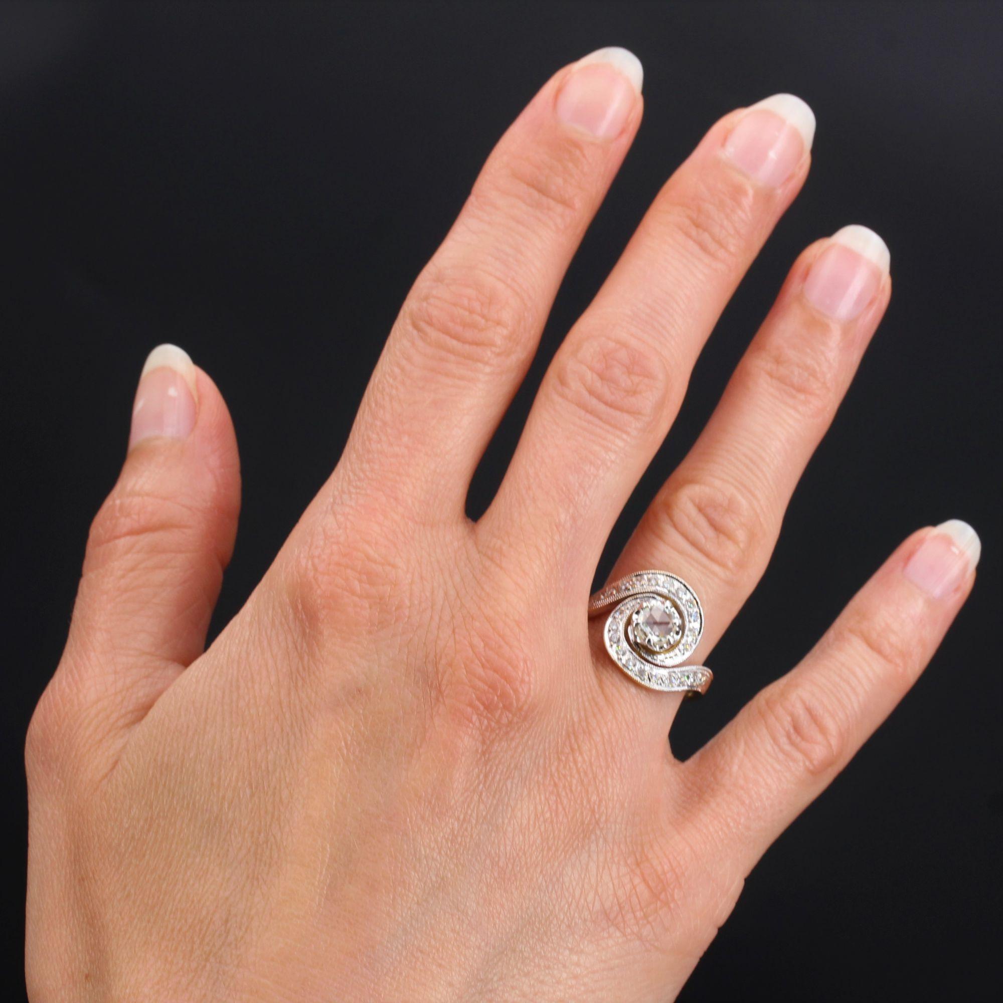 Ring in 18 karat yellow and white gold, eagle head hallmark.
Called a swirl ring, this 2-tone gold ring is set on top with a rose-cut diamond, claw-set. The whole swirl is set with brilliant- cut diamonds.
Weight of the central diamond : 0.26 carat