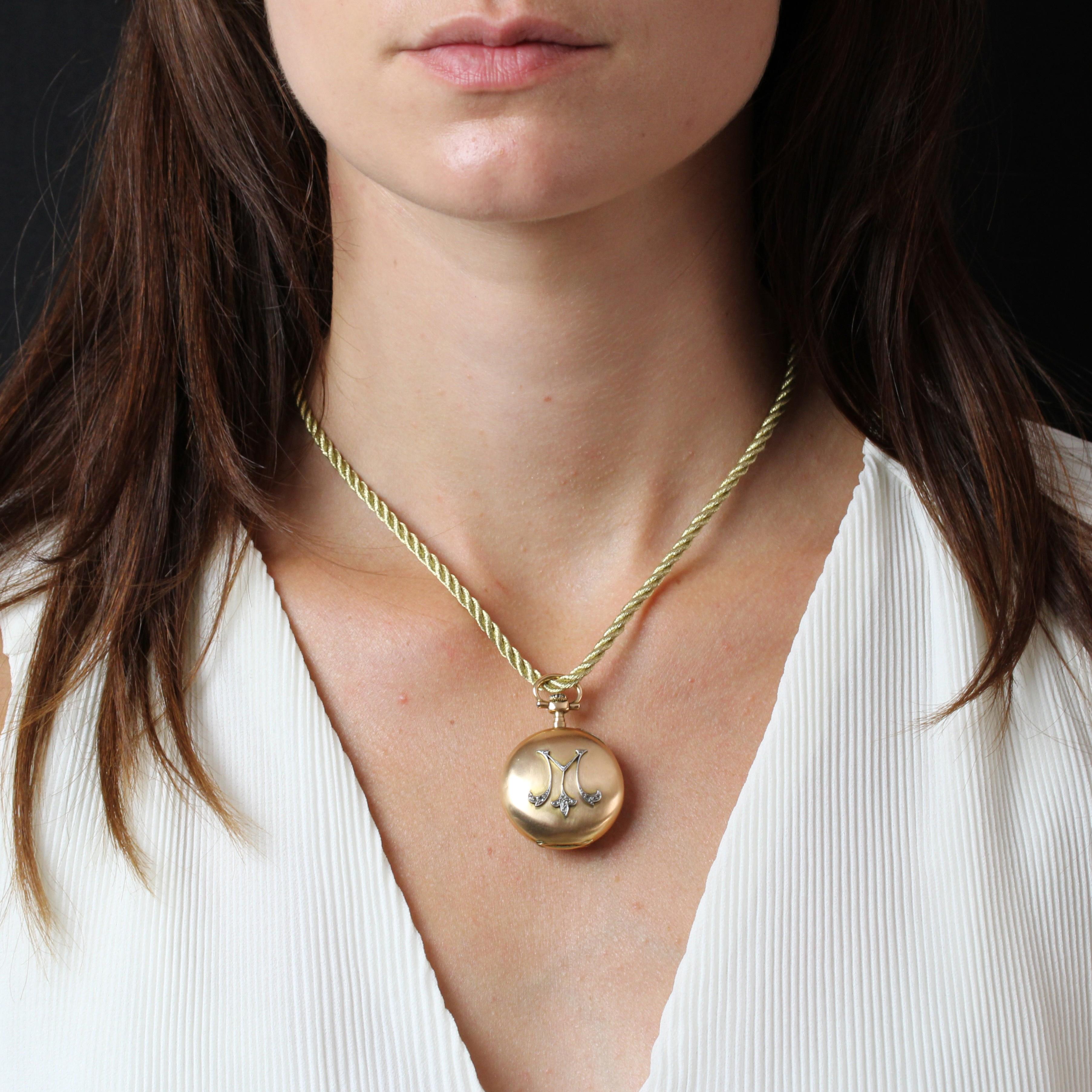 Montre-pendentif en or rose 18 carats.
Montre de poche pour femme avec un boîtier rond et bombé. Le fond est en émail blanc, avec des aiguilles en or et des chiffres arabes en émail noir. Le fond est en or brossé et décoré d'un motif A&M en