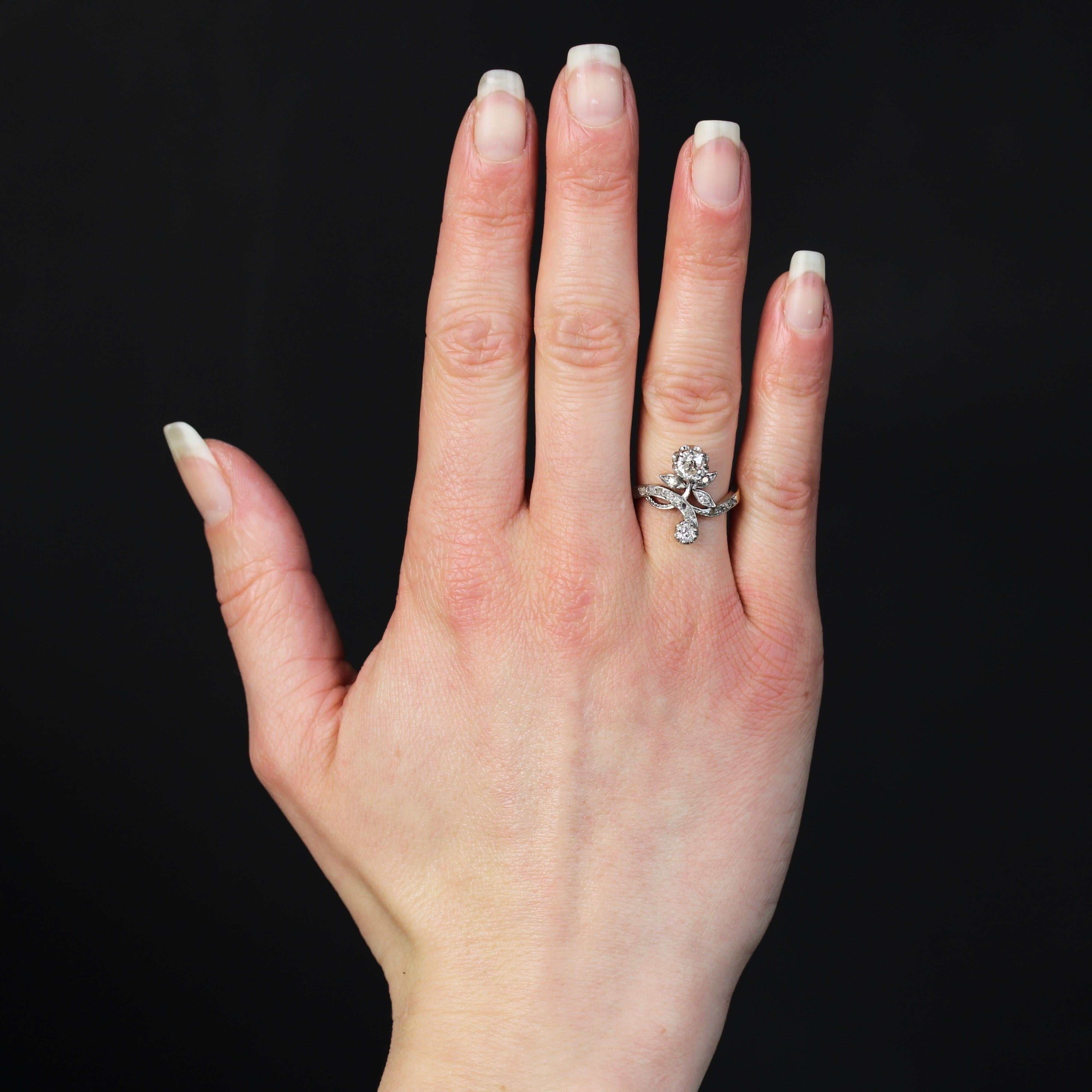 Ring aus 18 Karat Gelbgold, Pferdekopfpunze und Platin.
Ein femininer, authentischer Ring aus der Belle Epoque, der eine Rose stilisiert. Die Blüte wird durch einen Diamanten im Kissenschliff im antiken Stil dargestellt, die Blütenblätter sind mit