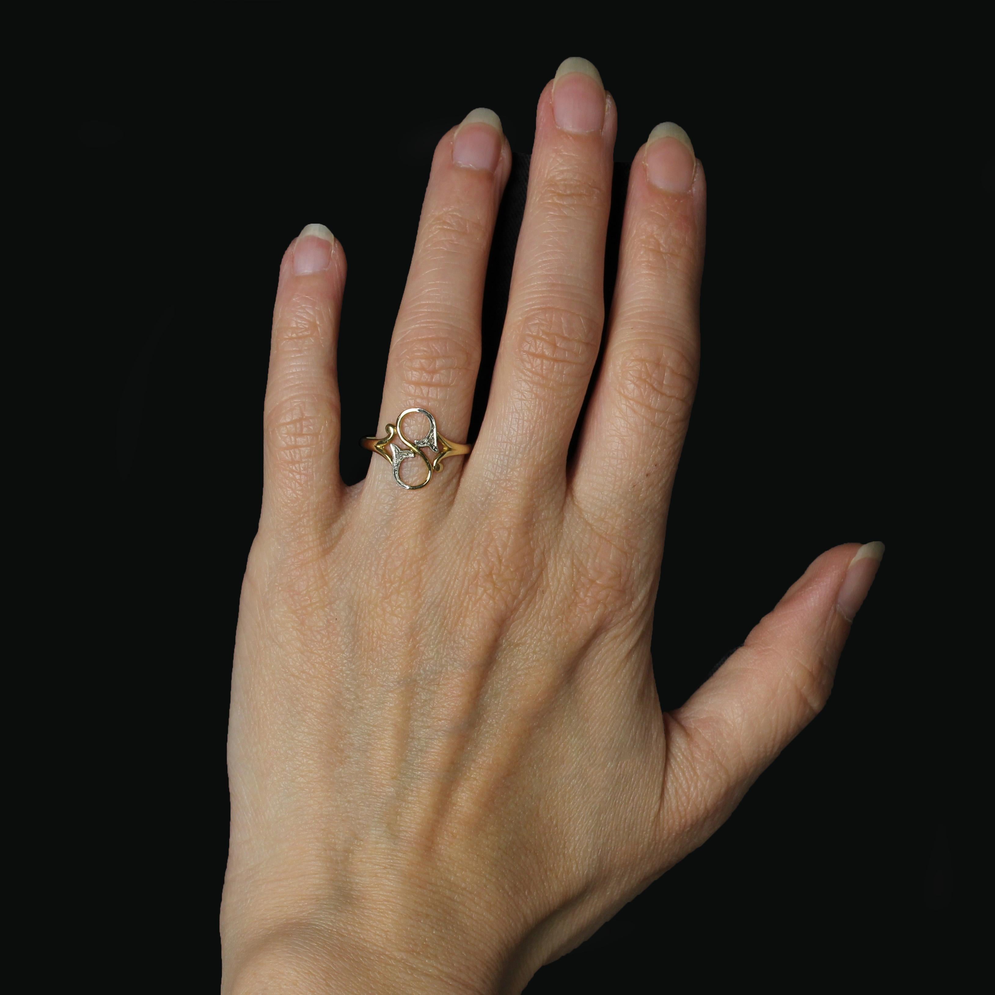 Ring in 18 karat yellow gold, eagle head hallmark.
Fine and delicate, this Belle Epoque ring features two openwork round motifs, each adorned with a diamond-set cornucopia motif, a setting reminiscent of the early You and Me rings of this artistic