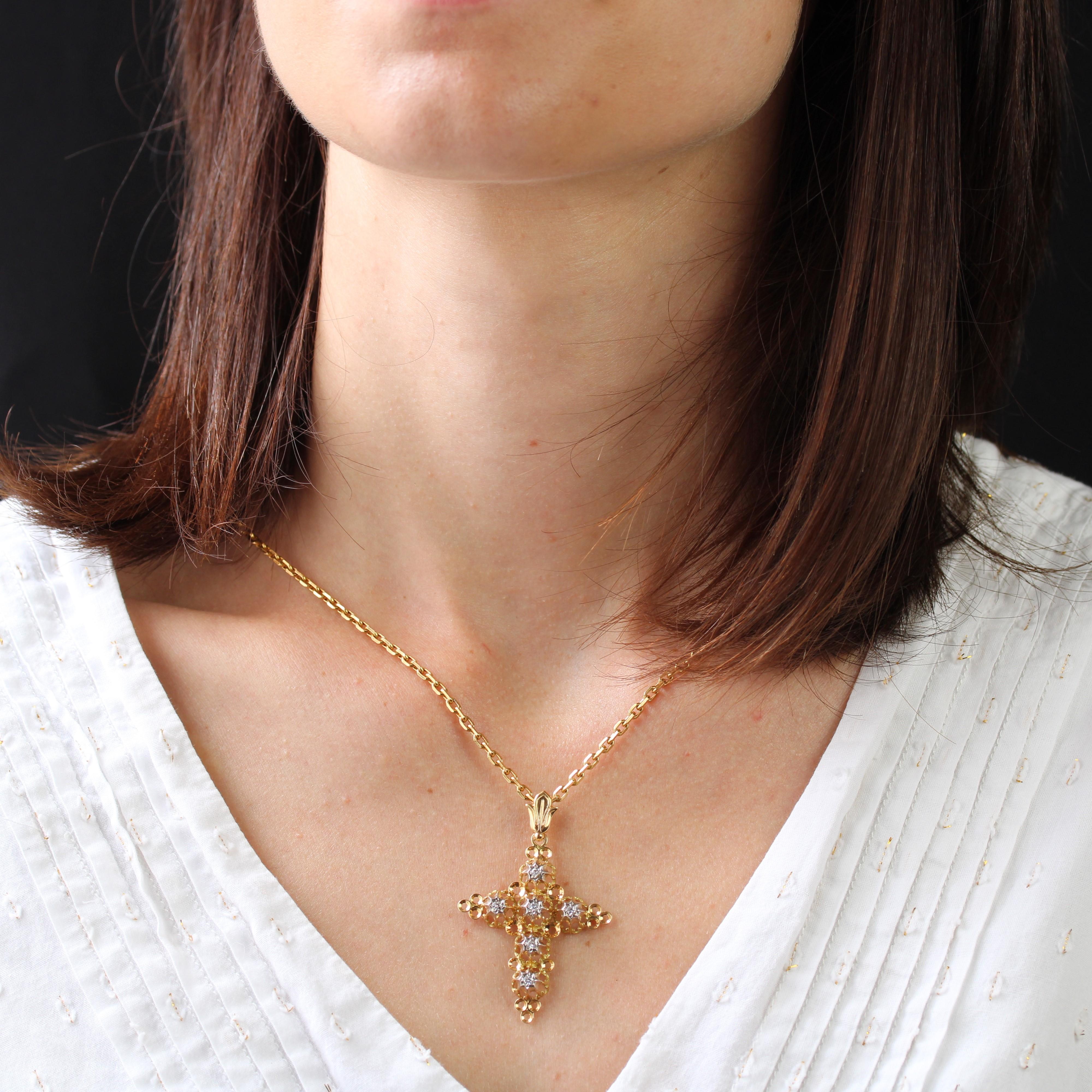 Cross in 18 karat yellow gold, eagle head hallmark.
This elegant antique cross features a fleur-de-lis motif on the bezel, which supports a cross made of openwork, fleur-de-lis and star motifs, with a small 8/8-cut diamond in the center. Small