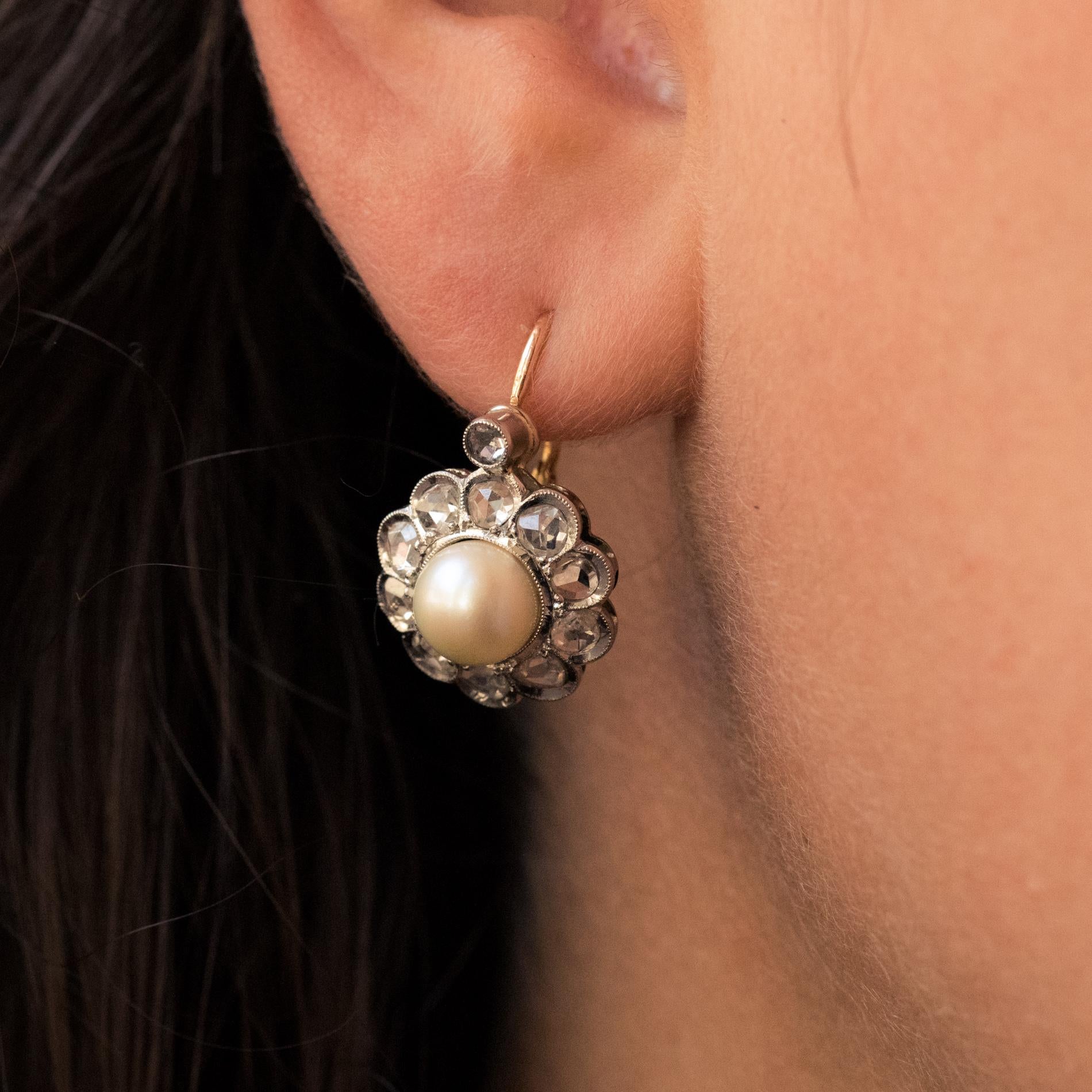 Earrings in 18 karat yellow gold, eagle's head hallmark and platinum.
Sublime antique lever- back earrings, each one represents a daisy whose heart is a pearly white round cultured pearl, and the petals are rose- cut diamonds. The all is surmounted