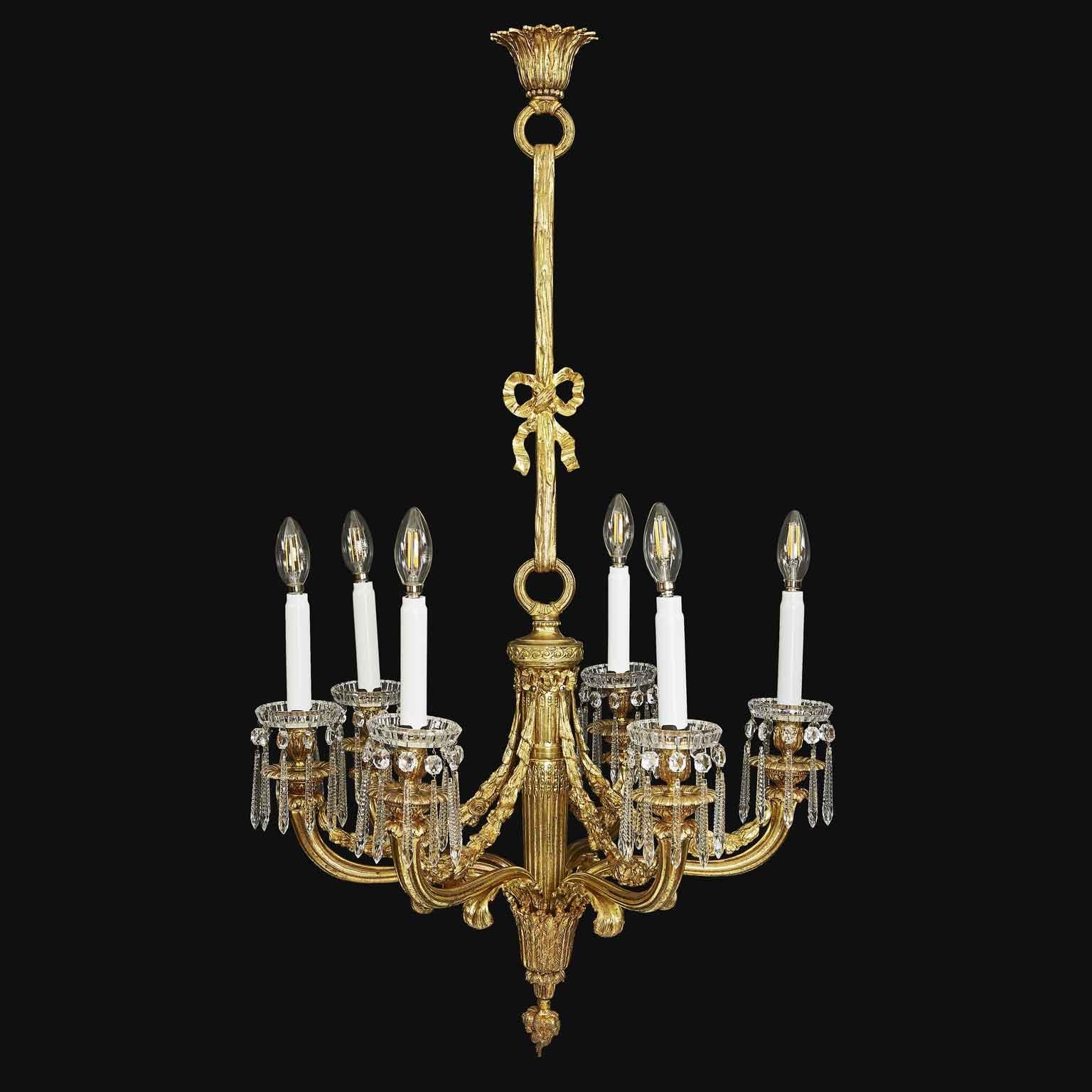 An elegant French early 20th century Empire style Baccarat crystal and ormolu chandelier. An early-20th century Baccarat Gilt Bronze Chandelier, elegant six-light French chandelier with E14 mignon mount, with a baluster stem decorated with a bow and