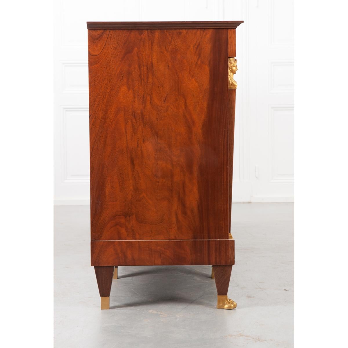 A good looking 20th century Empire-style enfilade. This mahogany piece comes from France and is in good condition. It has a green marble top sitting over four drawers. The two center drawers have keyholes and brass escutcheons with keys and the two