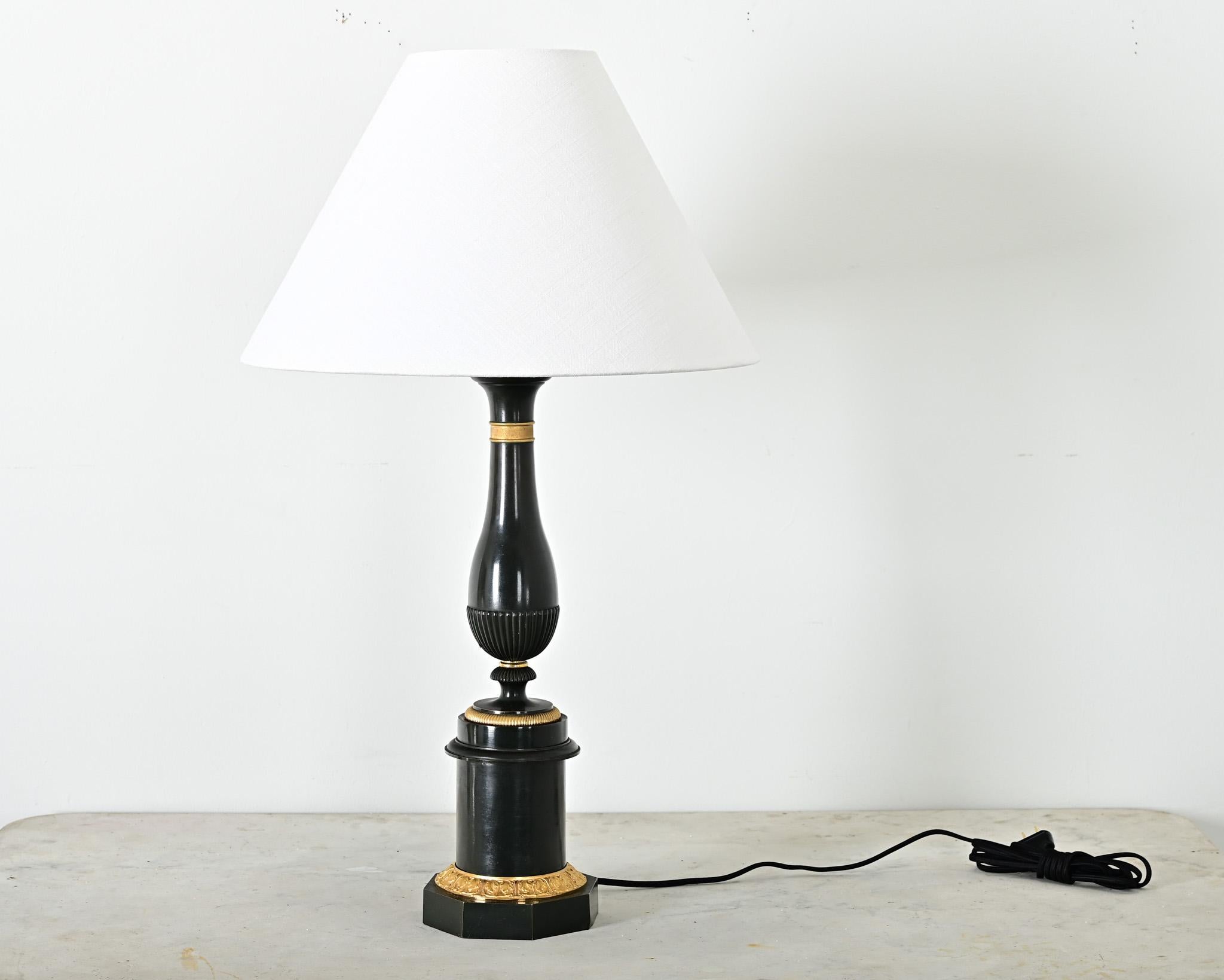Lampe de table de style Empire en métal laqué et bronze doré avec abat-jour en lin neuf. Cet imposant luminaire néoclassique présente une silhouette balustre attrayante en finition satinée vert foncé sur la colonne, avec des accents de bronze doré