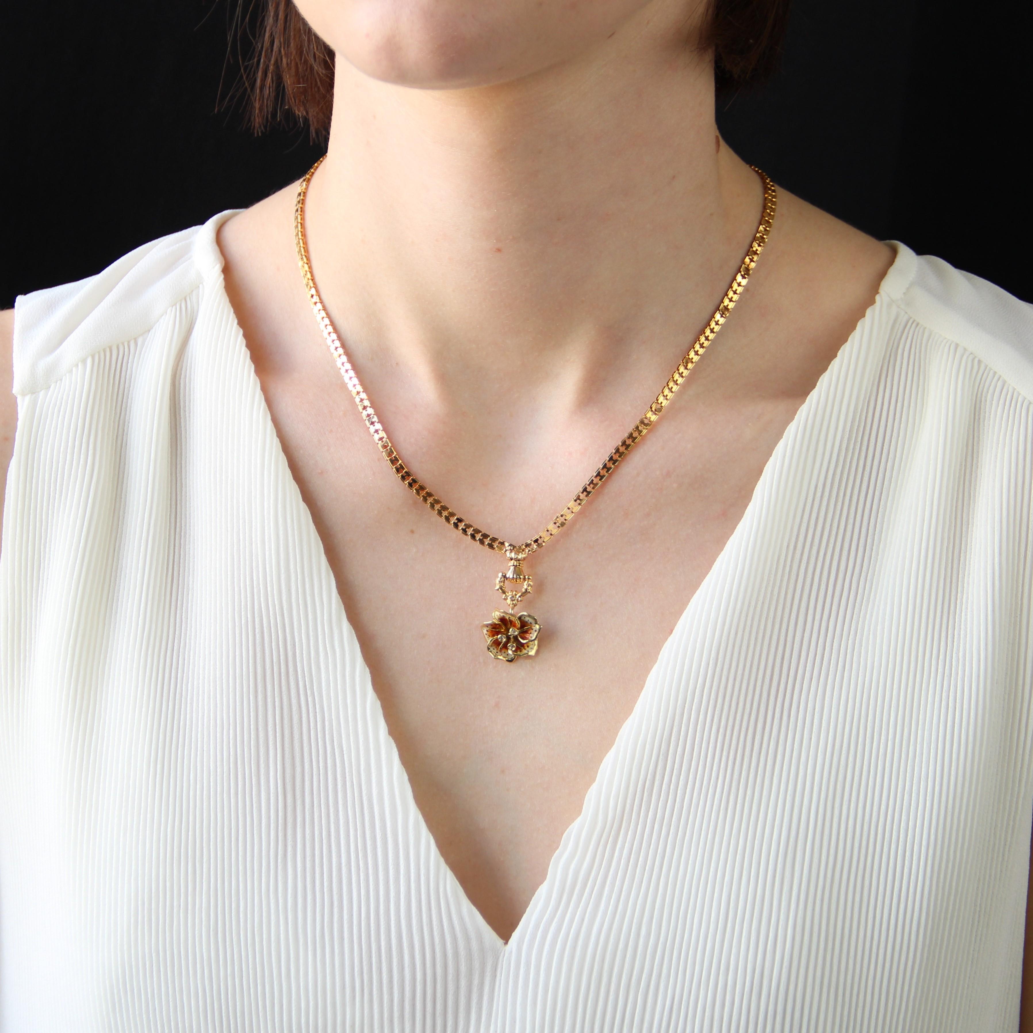Necklace in 18 karat yellow gold, mixed hallmark.
This charming antique gold necklace is formed of a flat mesh clasp that holds on the front a pattern formed by a gloved hand, holding a stirrup chased with floral motifs, all supporting a pansy