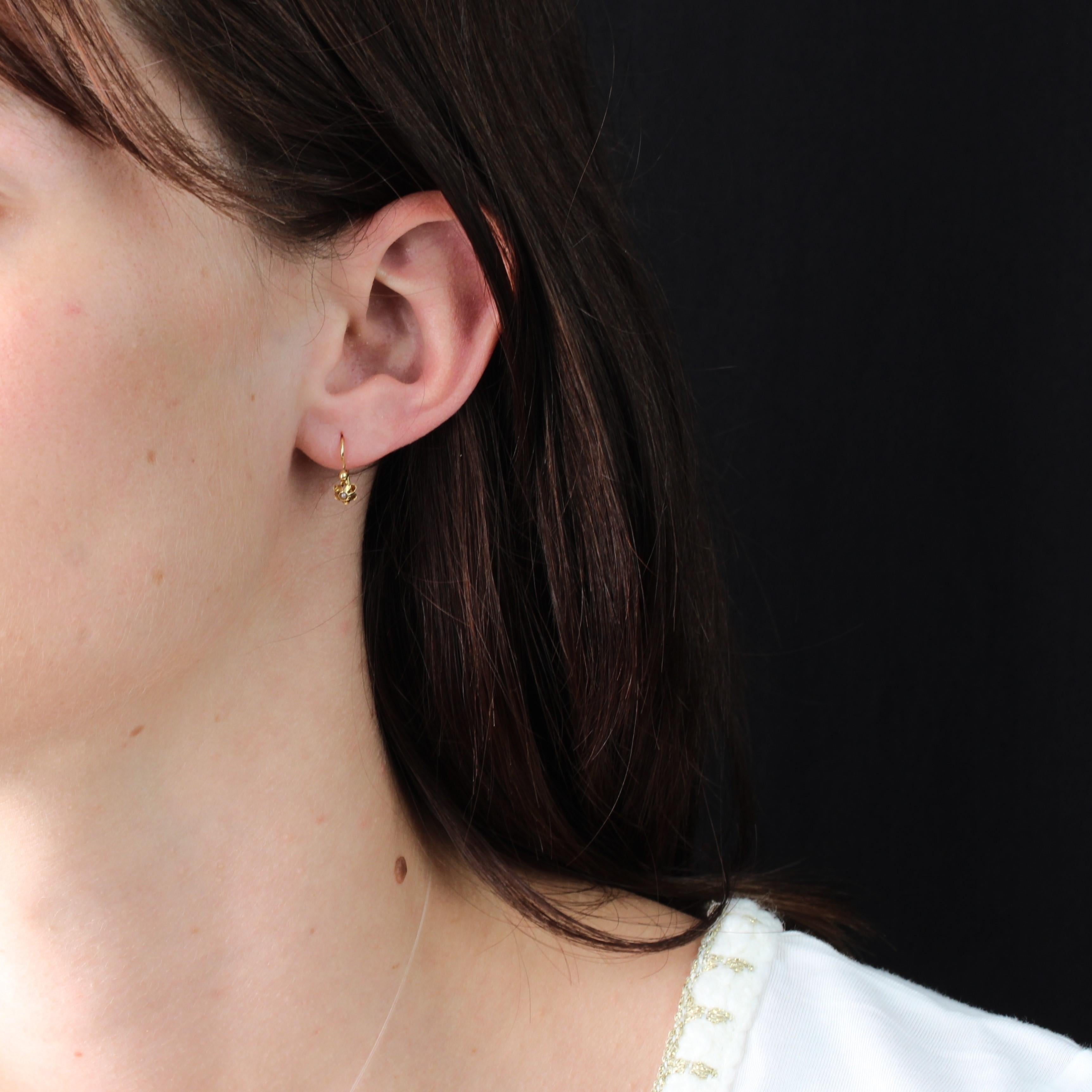 Per le orecchie forate.
Orecchini in oro giallo 18 carati, con marchio a testa d'aquila.
Piccoli orecchini antichi con chiusura a leva, formano un fiore il cui centro è ornato da alte griffe di una mezza perla, presumibilmente fine, incastonata in