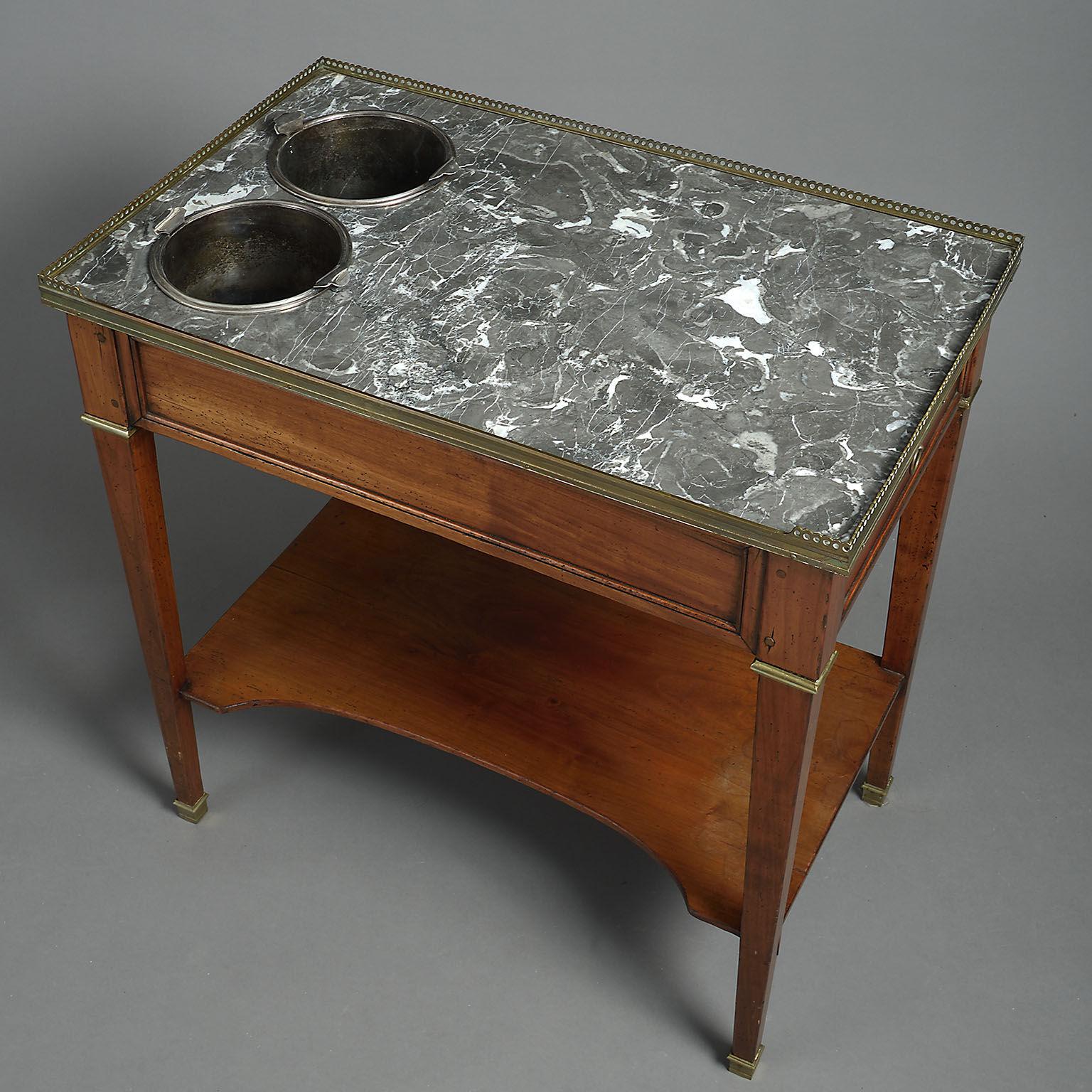 French fruitwood rafraîchissoir or champagne table in the Louis XVI style, the rectangular grey marble-top pierced to take two silver plated wine-coolers, the frieze with a single drawer to one end and raised on square tapering legs with brass