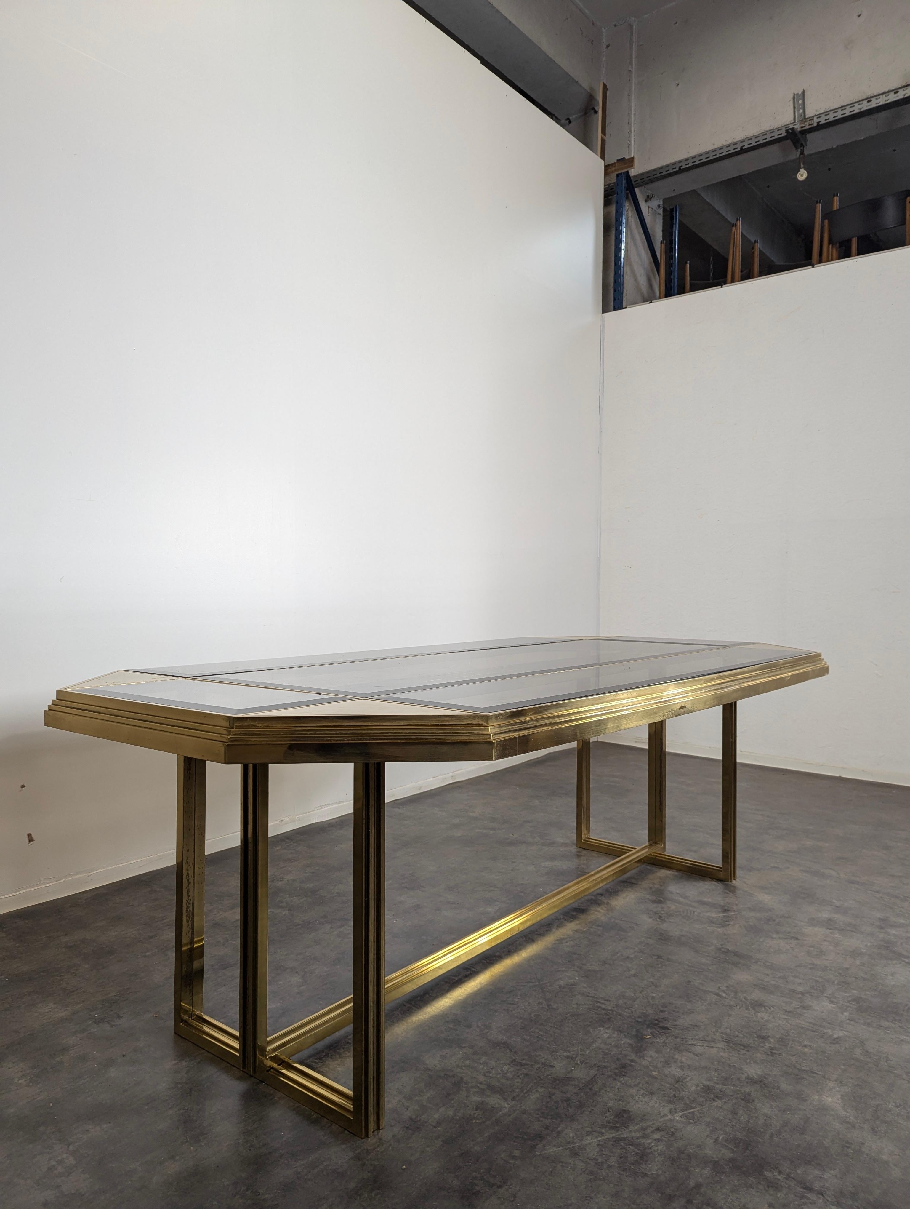 This French 20th-century dining table attributed to Maison Jansen captures the refined elegance of mid-century modern design with a luxurious blend of glass and brass. The table features a sleek glass top that creates a sense of openness and