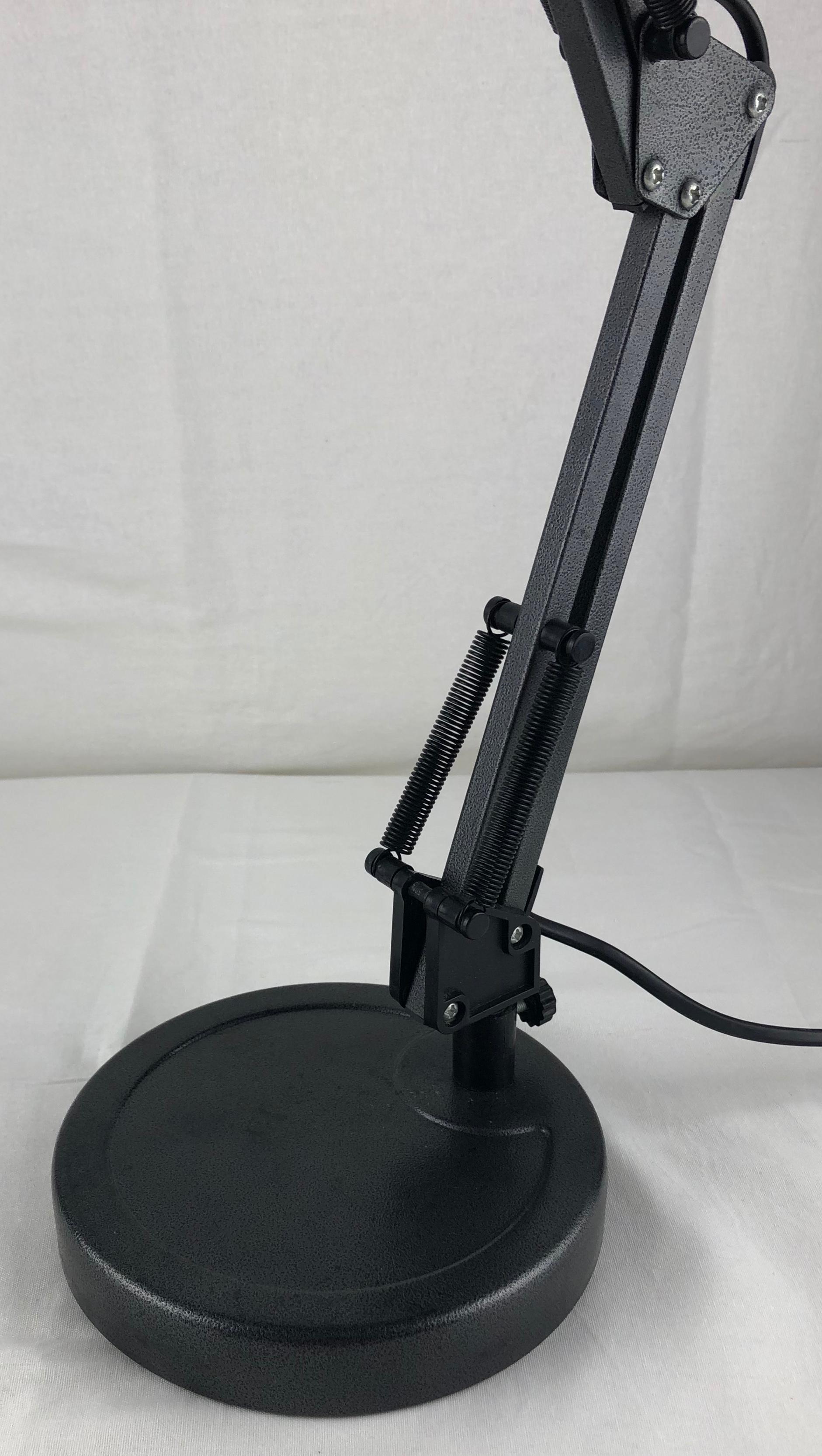 Handsome articulating desk or table lamp in painted aluminum, dark grey.

Vintage French industrial steel articulated table lamp. Lamps like these were originally used as task lamps in factories, but are perfect now as bedside lamps or on side