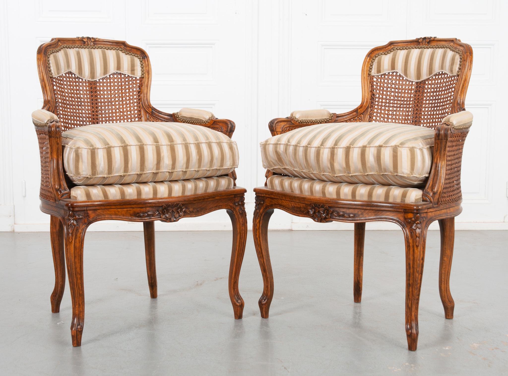 A pair of early 20th century Louis XV style oak frame chairs. Recently upholstered with cut silk and velvet fabric, the seat height is 18” without the cushion and 24’’ with the cushion. The caning is in great condition, stained to match the rich