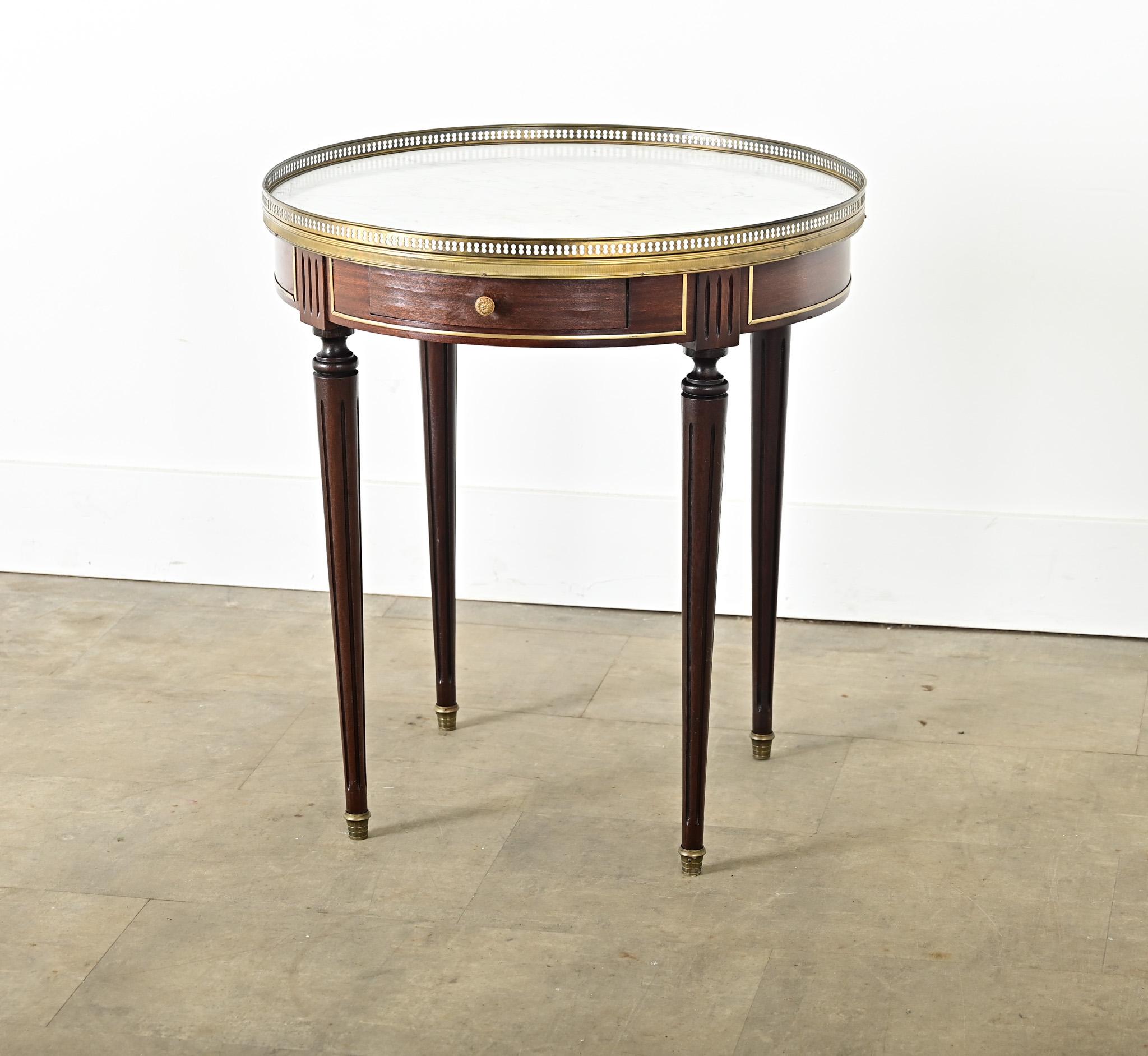 This charming 20th Century Louis XVI style mahogany gueridon makes a fine addition to any traditional or transitional interior, made with the care and techniques as a period original. The white marble top is in remarkable condition with minimal
