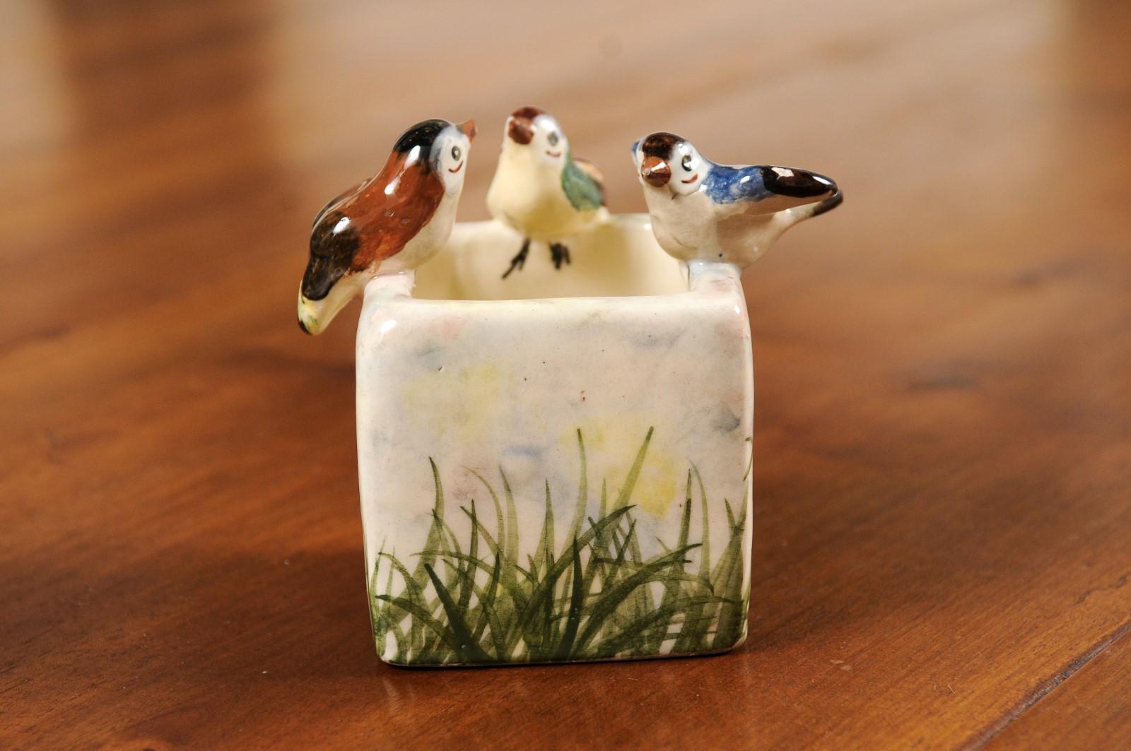 A French majolica decorative container from the 20th century, with three little birds and painted grass. Created in France during the 20th century, this petite container features a rectangular body topped with three lovely birds perched on the edge