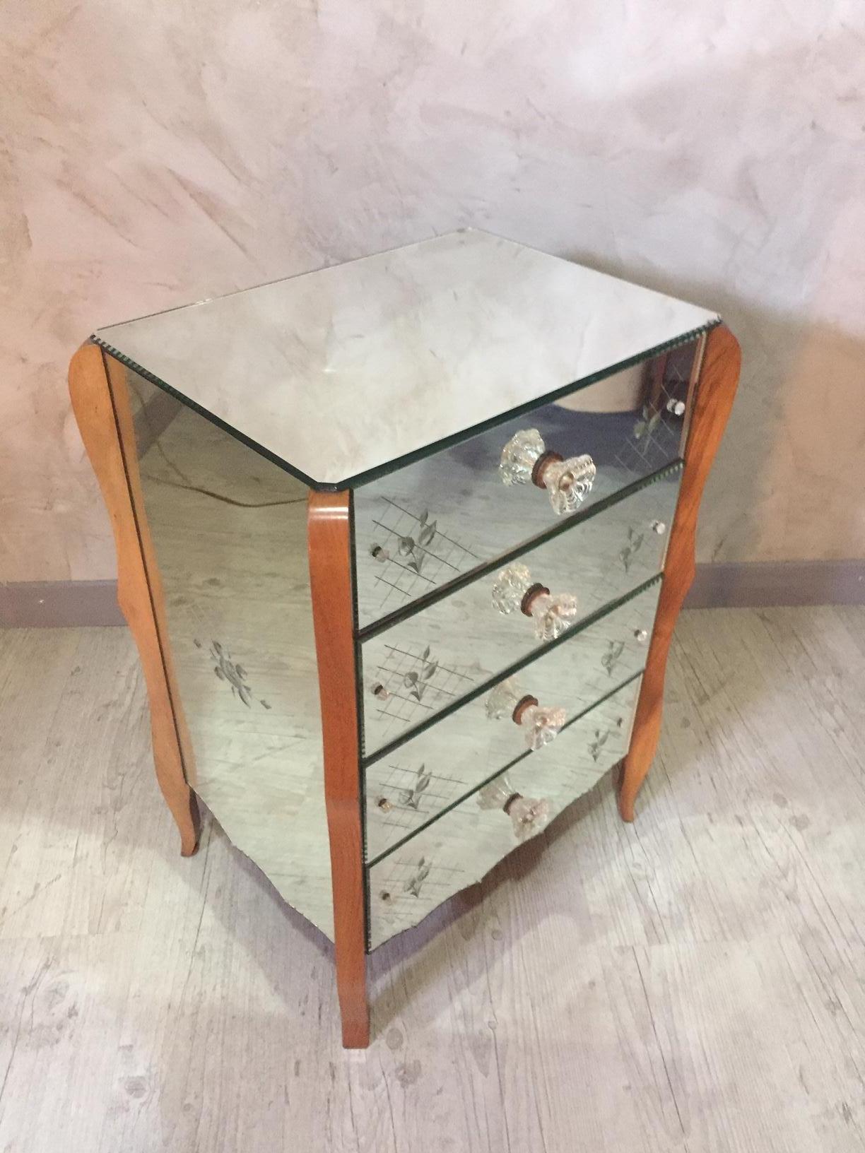 Beautiful 20th century mirror chest of drawer from the 1950s
Extraordinary handles designed as solid glass rossettes characterizes the front of the chest. The glass is completely original but it shows some color changes. Perfect condition (not