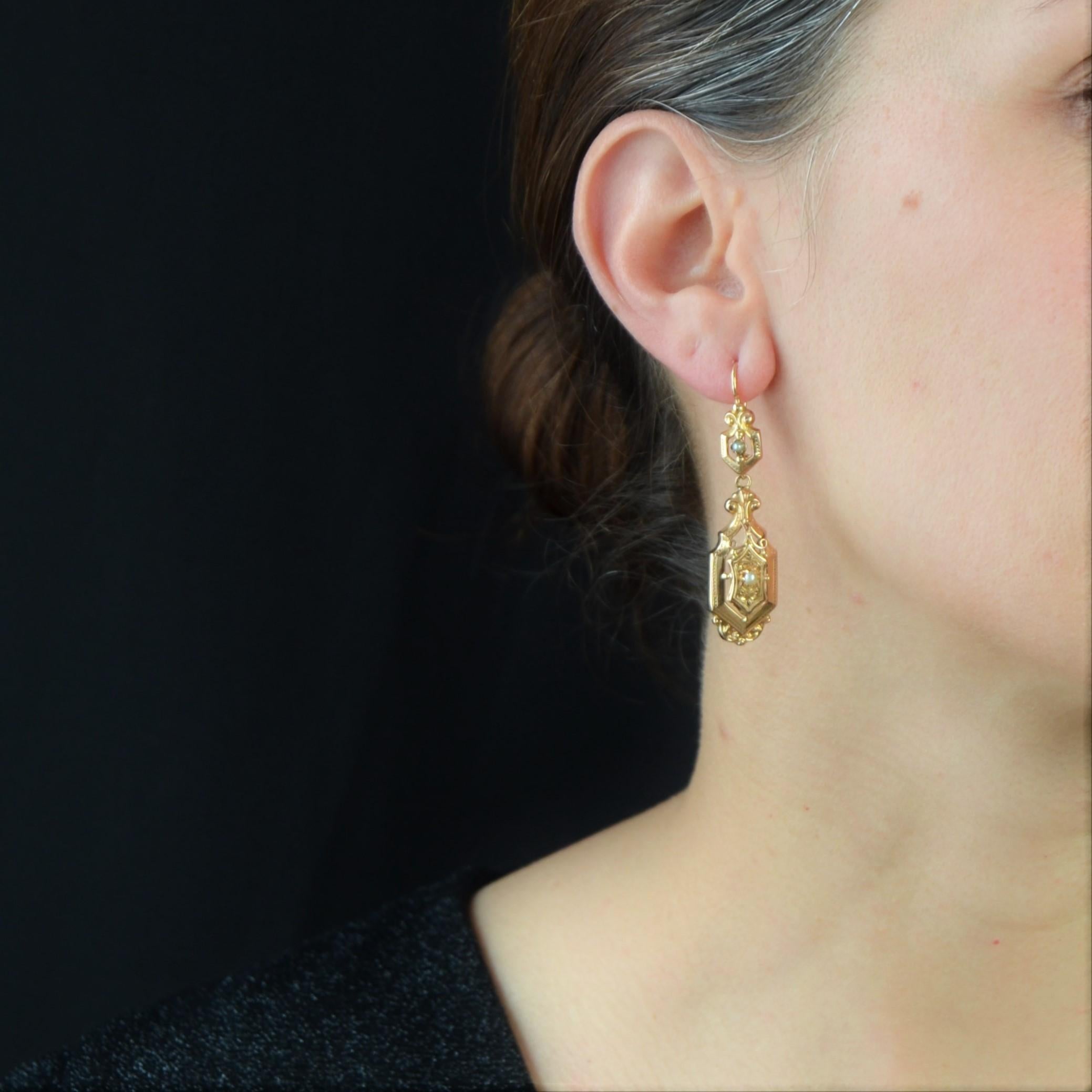 For pierced ears.
Pair of earrings in 18 karat rose gold, eagle head and horse head hallmarks.
Lovely earrings, they are made of a diamond-shaped openwork, chiseled, decorated in the center of a half pearl and topped by an arabesque. This pattern