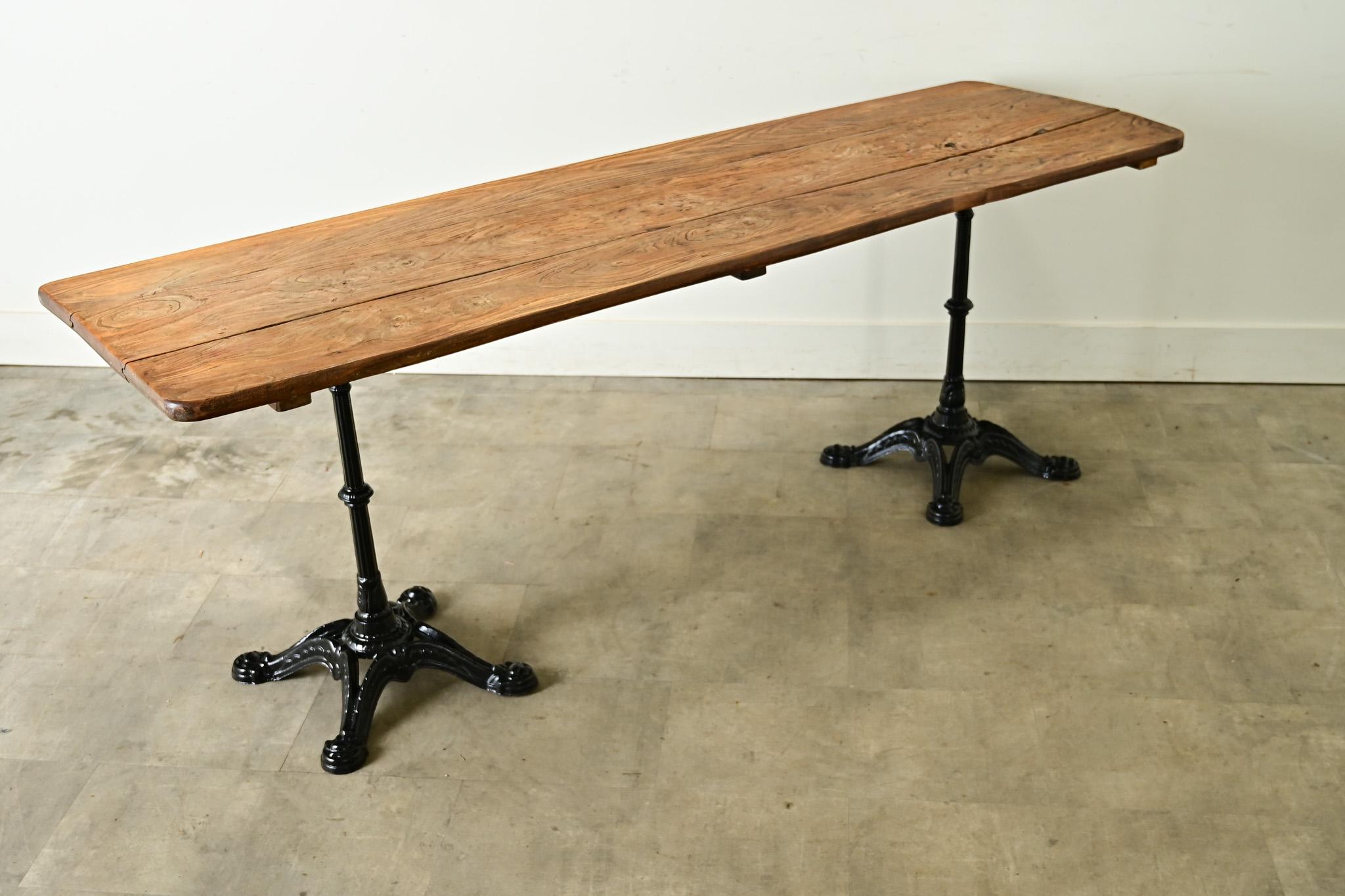 Una característica mesa de bistró francesa de principios del siglo XX, de proporciones largas y estrechas para acoger fácilmente al menos a seis comensales. Levantada sobre dos bases de hierro fundido de estilo Beaux Arts, la encimera alargada de