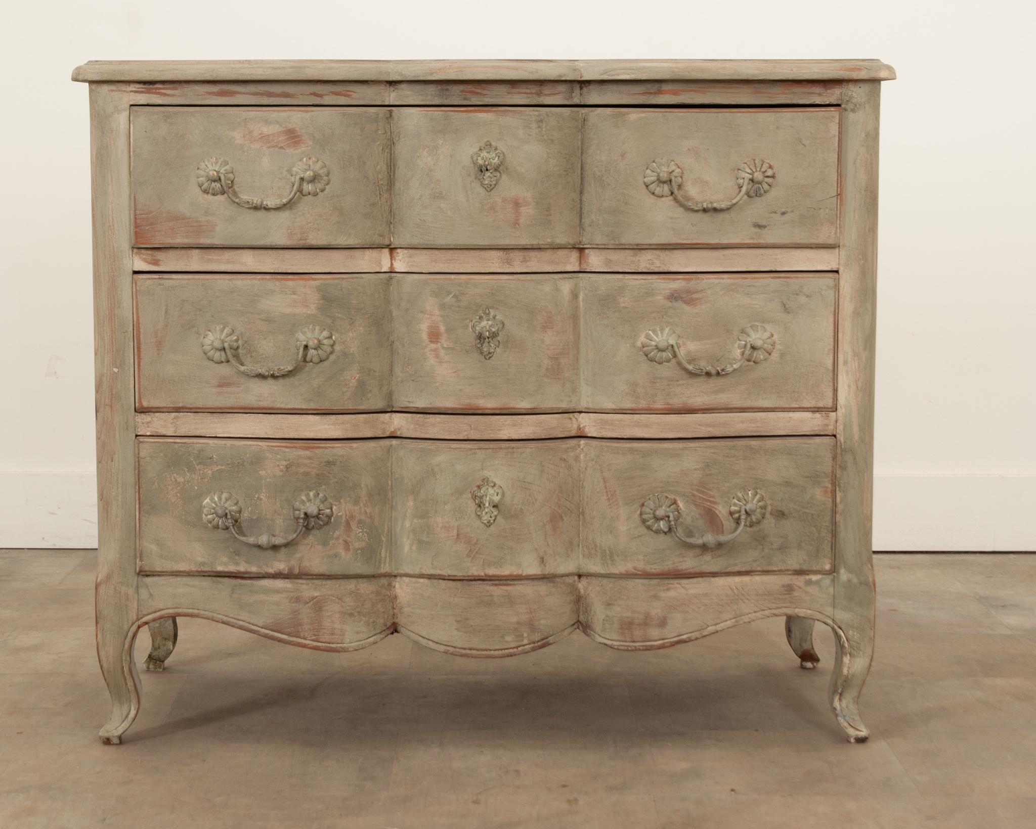 A fabulous shaped skirt and cabriole legs make this 20th century French stripped and painted commode a standout. This recently painted case piece incorporates elements of both Louis XV and Regence styles. The shaped top with a curvy molded edge is