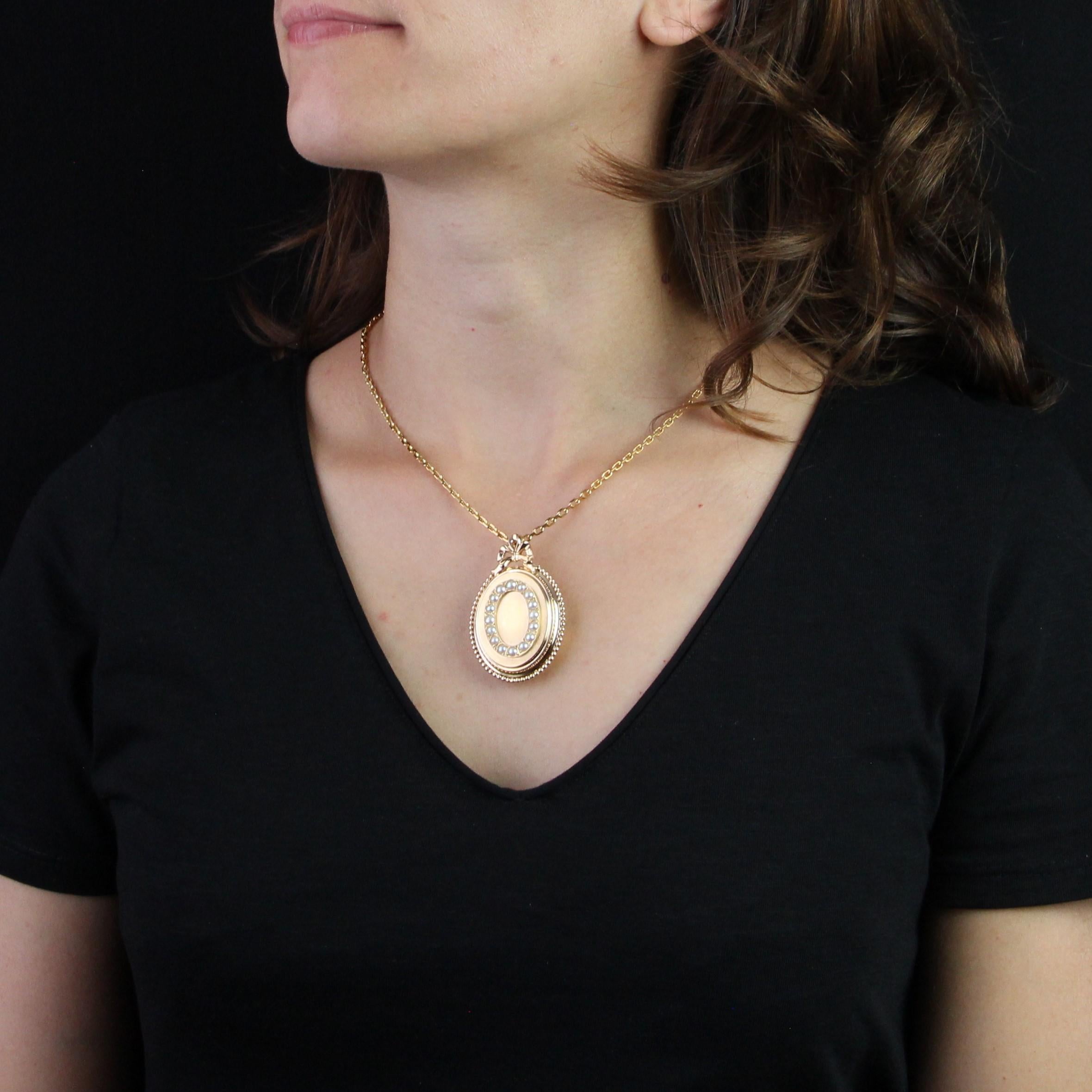 Pendant in 18 karat rose gold, eagle head hallmark.
Antique opening pendant, it is of oval shape and decorated in application on the top of half pearls. The border is decorated with a pearl and the strap hidden behind a draped knot in gold. It has 2