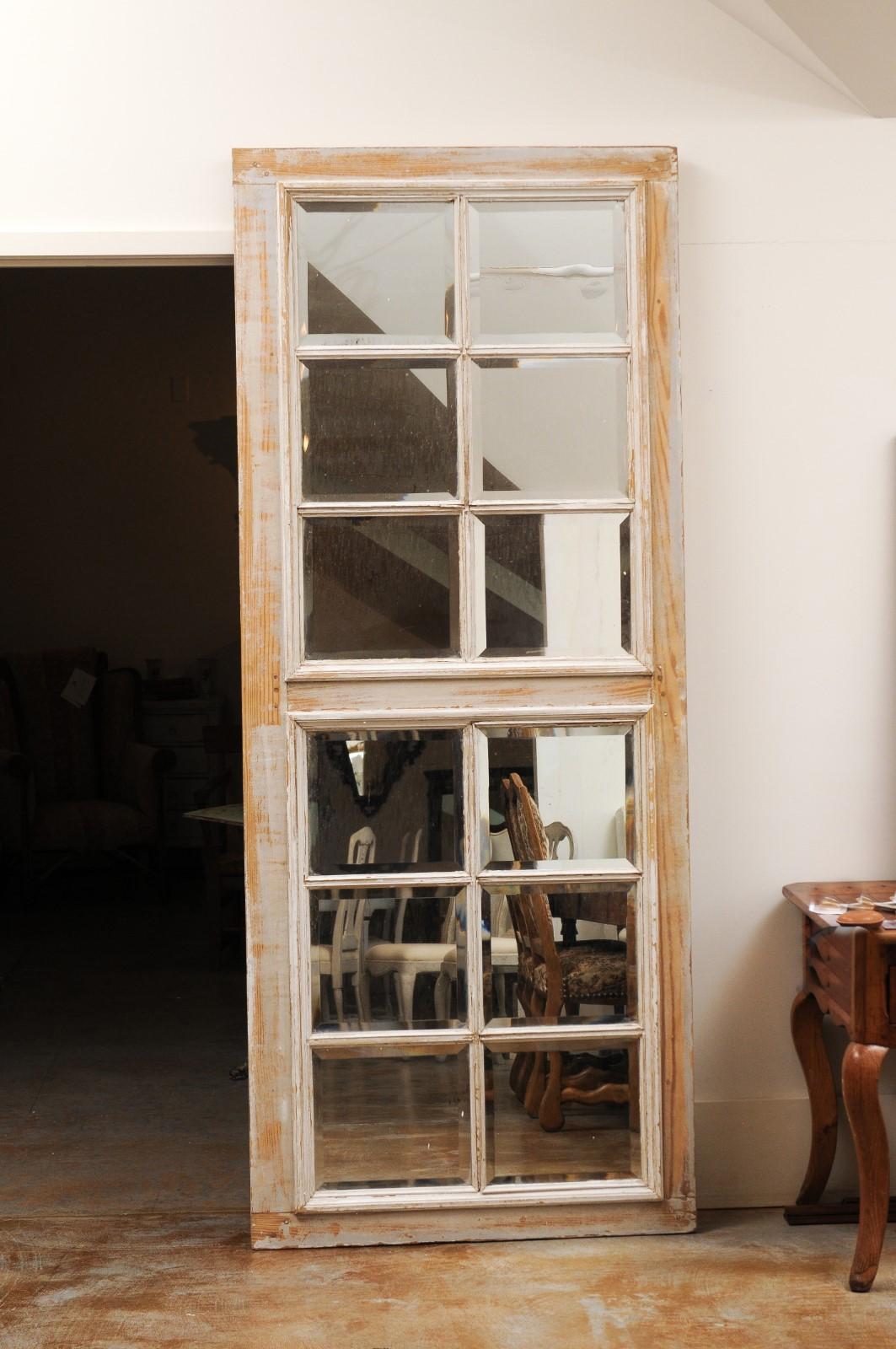 A French rectangular over door mirrored panel from the 20th century, with scraped finish. Charming us with its clean lines and scraped finish, this rectangular over door panel is made of two sections each showcasing paneled mirrors with beveled