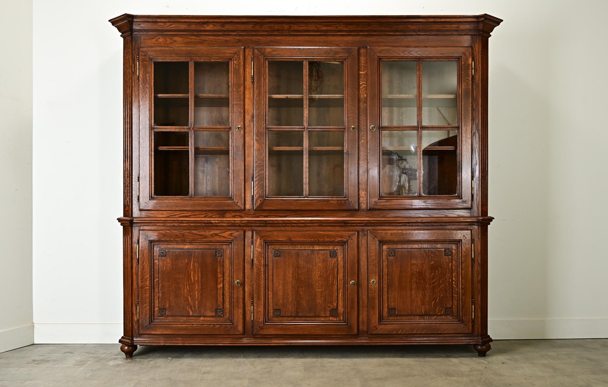 Eine beeindruckende Bibliothek aus massivem Eichenholz aus dem Frankreich des frühen 20. Jahrhunderts, die zum leichteren Aufstellen und Transportieren in zwei Teile geteilt ist. Unter einem von Louis Philippe inspirierten Gesims mit abgewinkelten