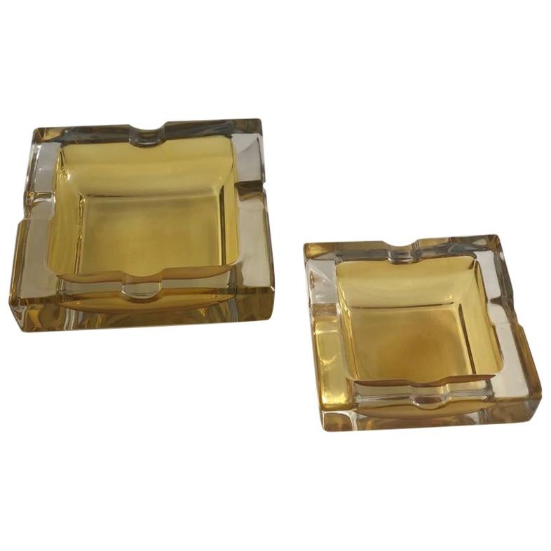 A pair of midcentury vintage heavy glass square ashtrays of two different sizes circa 1960s in rectangular Art Deco design of bicolor transparent and yellow hues.

France, circa 1950s. 
Beautiful condition with very light age related signs.