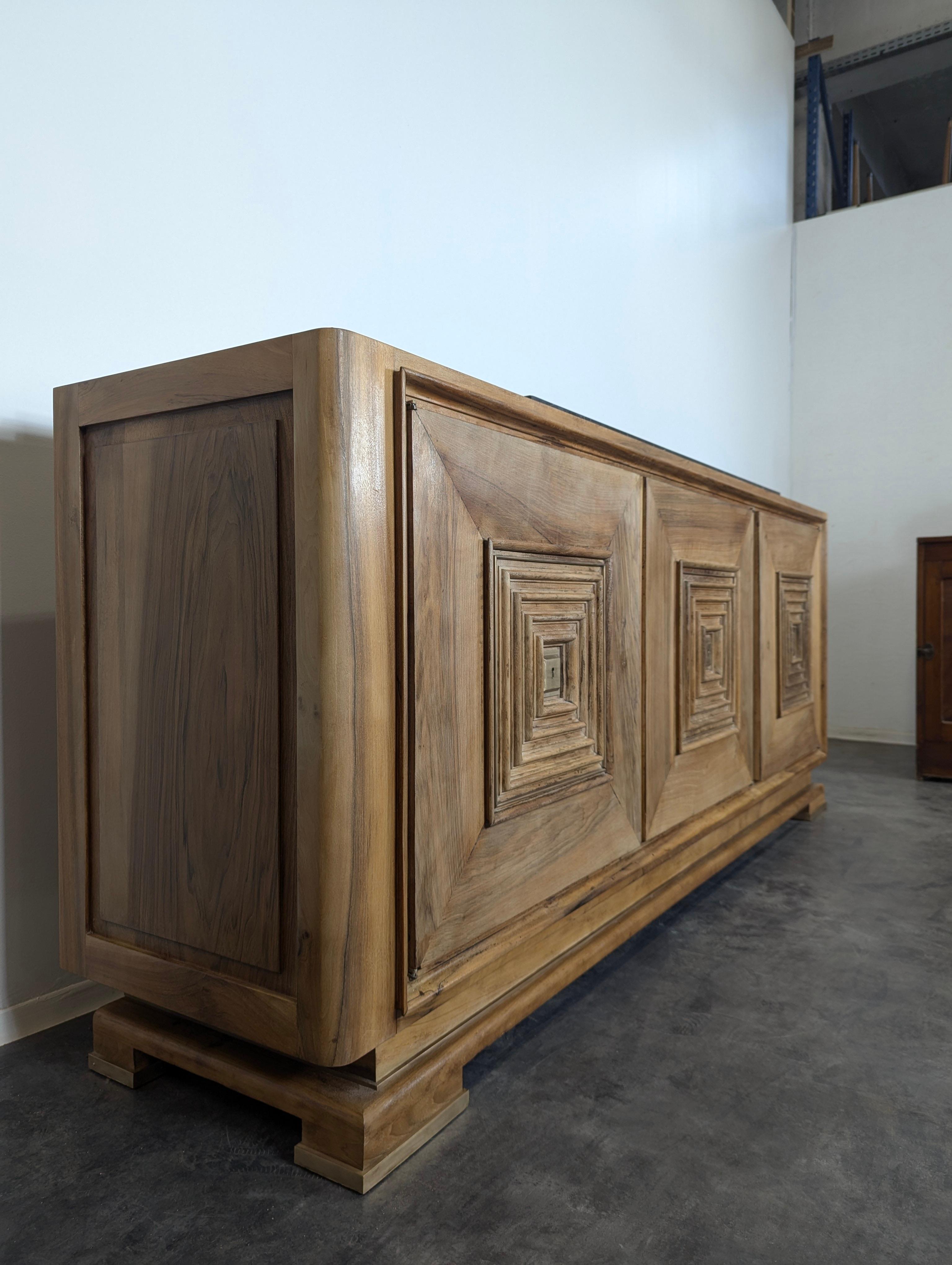 This French 20th-century walnut sideboard by Maxime Old showcases a refined blend of Rustic design and modern elegance. Crafted from rich walnut, the sideboard highlights the natural beauty of the wood, with its deep, warm tones and visible grain